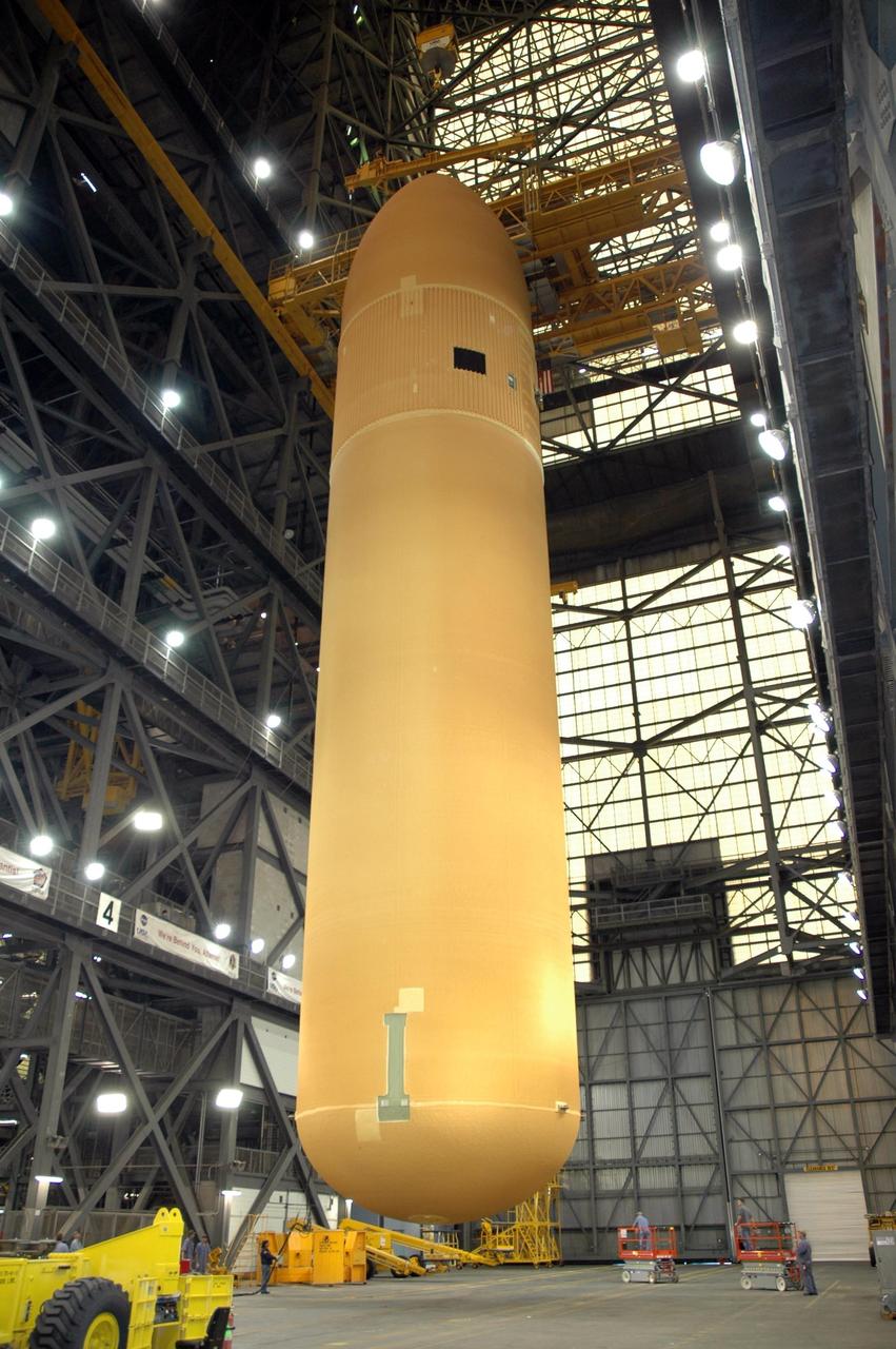KENNEDY SPACE CENTER, FLA.  -  In the transfer aisle of NASA Kennedy Space Center's Vehicle Assembly Building, the newly delivered external tank is suspended vertically just above the floor.  Designated ET-119, the 154-foot tank will be lifted into a checkout cell for further work.  The tank, which will launch space shuttle Discovery on mission STS-121, will fly with many major safety changes, including the removal of the protuberance air load ramps. A large piece of foam from a ramp came off during the last shuttle launch in July 2005. The ramps were removed to eliminate a potential source of damaging debris to the space shuttle. The next launch of Discovery is scheduled for May 2006. Photo credit: NASA/Jim Grossmann