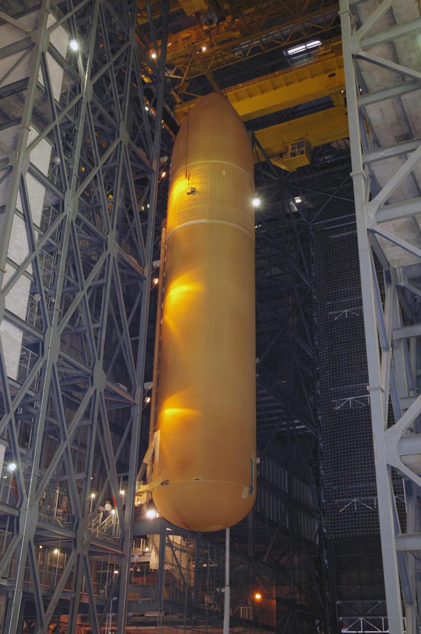 KENNEDY SPACE CENTER, FLA. - From the upper regions of NASA Kennedy Space Center's Vehicle Assembly Building, the newly delivered external tank is lowered toward a checkout cell for further work. Designated ET-119, the 154-foot tank will be lifted into a checkout cell for further work. The tank, which will launch space shuttle Discovery on mission STS-121, will fly with many major safety changes, including the removal of the protuberance air load ramps. A large piece of foam from a ramp came off during the last shuttle launch in July 2005. The ramps were removed to eliminate a potential source of damaging debris to the space shuttle. The next launch of Discovery is scheduled for May 2006. Photo credit: NASA/Jim Grossmann