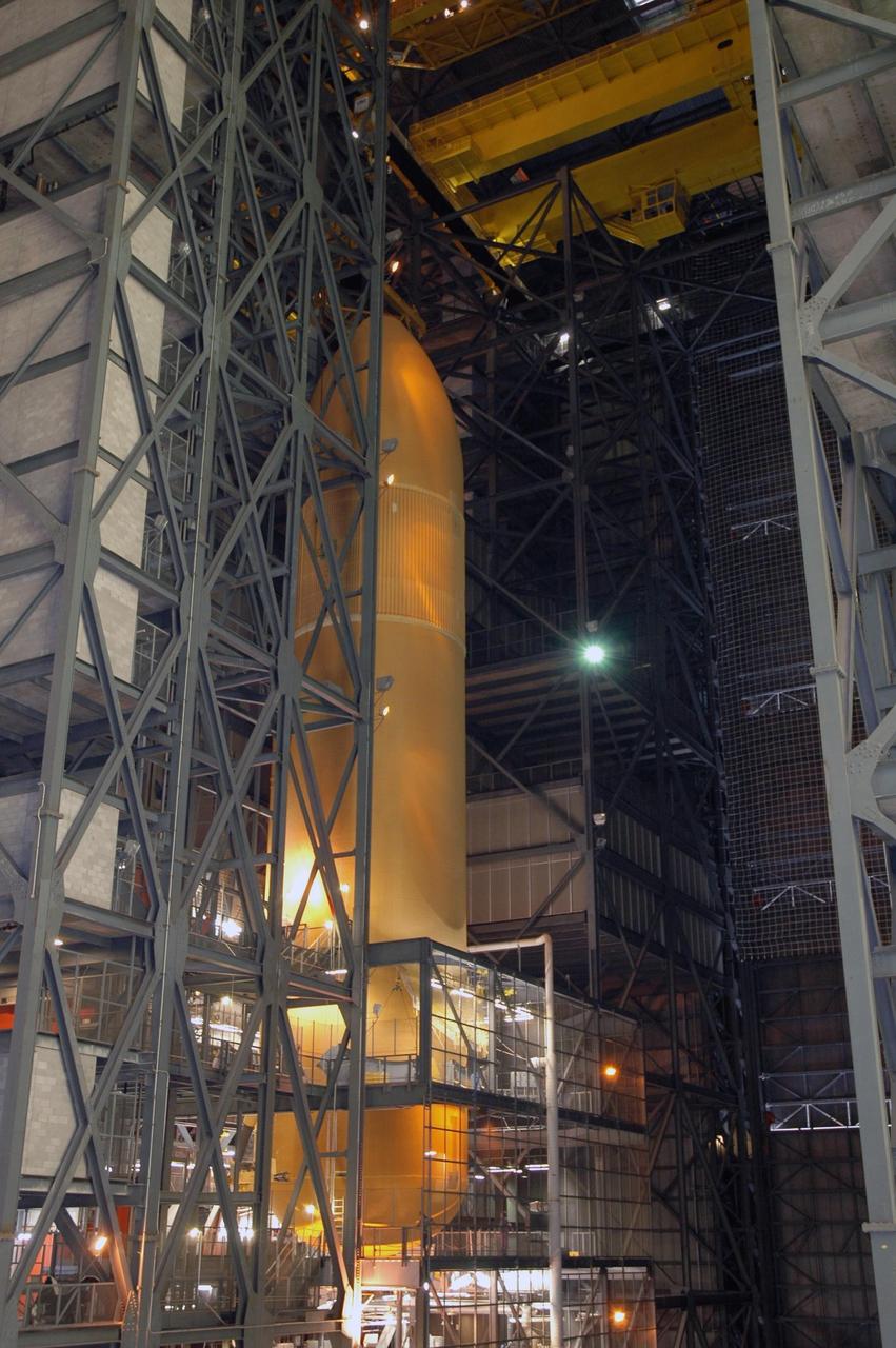 KENNEDY SPACE CENTER, FLA. - From the upper regions of NASA Kennedy Space Center's Vehicle Assembly Building, the newly delivered external tank is lowered into a checkout cell for further work. Designated ET-119, the 154-foot tank will be lifted into a checkout cell for further work. The tank, which will launch space shuttle Discovery on mission STS-121, will fly with many major safety changes, including the removal of the protuberance air load ramps. A large piece of foam from a ramp came off during the last shuttle launch in July 2005. The ramps were removed to eliminate a potential source of damaging debris to the space shuttle. The next launch of Discovery is scheduled for May 2006. Photo credit: NASA/Jim Grossmann