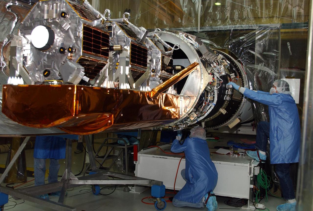 VANDENBERG AIR FORCE BASE, CALIF. -Inside Orbital Sciences’ Building 1555 at Vandenberg Air Force Base in California, a worker checks connections on the Space Technology 5 (ST5) spacecraft before encapsulation with the fairing.  The ST5, mated to Orbital Sciences' Pegasus XL launch vehicle, contains three microsatellites with miniaturized redundant components and technologies.   Each will validate New Millennium Program selected technologies, such as the Cold Gas Micro-Thruster and X-Band Transponder Communication System.  After deployment from the Pegasus, the micro-satellites will be positioned in a “string of pearls” constellation that demonstrates the ability to position them to perform simultaneous multi-point measurements of the magnetic field using highly sensitive magnetometers.  The data will help scientists understand and map the intensity and direction of the Earth’s magnetic field, its relation to space weather events, and affects on our planet.  With such missions, NASA hopes to improve scientists’ ability to accurately forecast space weather and minimize its harmful effects on space- and ground-based systems.  Launch of ST5 is scheduled from the belly of an L-1011 carrier aircraft no earlier than March 14 from Vandenberg Air Force Base.