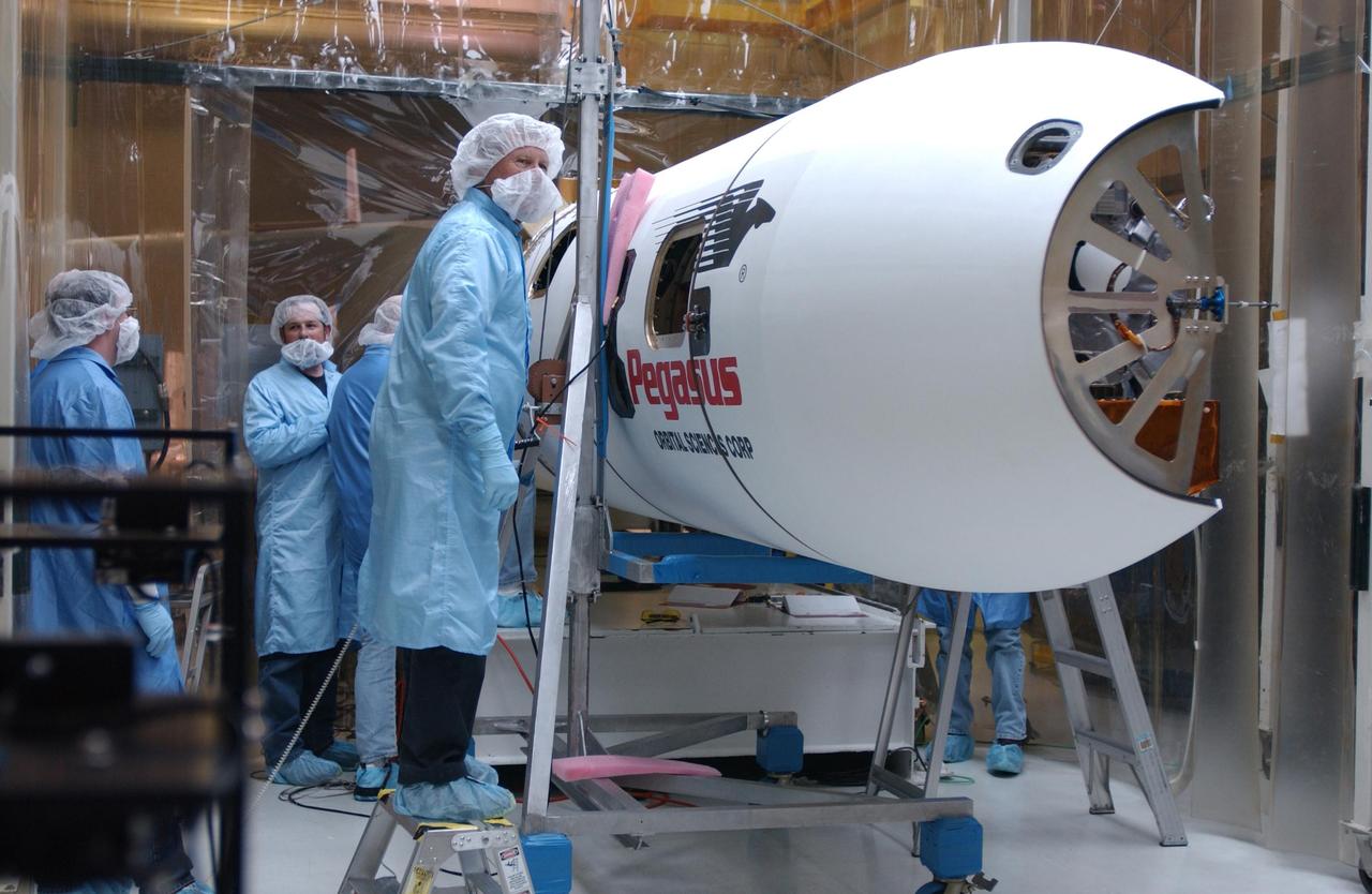 VANDENBERG AIR FORCE BASE, CALIF. - Inside Orbital Sciences’ Building 1555 at Vandenberg Air Force Base in California, workers check the Orbital Sciences' Pegasus XL launch vehicle before encapsulation of the Space Technology 5 (ST5) spacecraft.  The ST5 contains three microsatellites with miniaturized redundant components and technologies.   Each will validate New Millennium Program selected technologies, such as the Cold Gas Micro-Thruster and X-Band Transponder Communication System.  After deployment from the Pegasus, the micro-satellites will be positioned in a “string of pearls” constellation that demonstrates the ability to position them to perform simultaneous multi-point measurements of the magnetic field using highly sensitive magnetometers.  The data will help scientists understand and map the intensity and direction of the Earth’s magnetic field, its relation to space weather events, and affects on our planet.  With such missions, NASA hopes to improve scientists’ ability to accurately forecast space weather and minimize its harmful effects on space- and ground-based systems.  Launch of ST5 is scheduled from the belly of an L-1011 carrier aircraft no earlier than March 14 from Vandenberg Air Force Base.