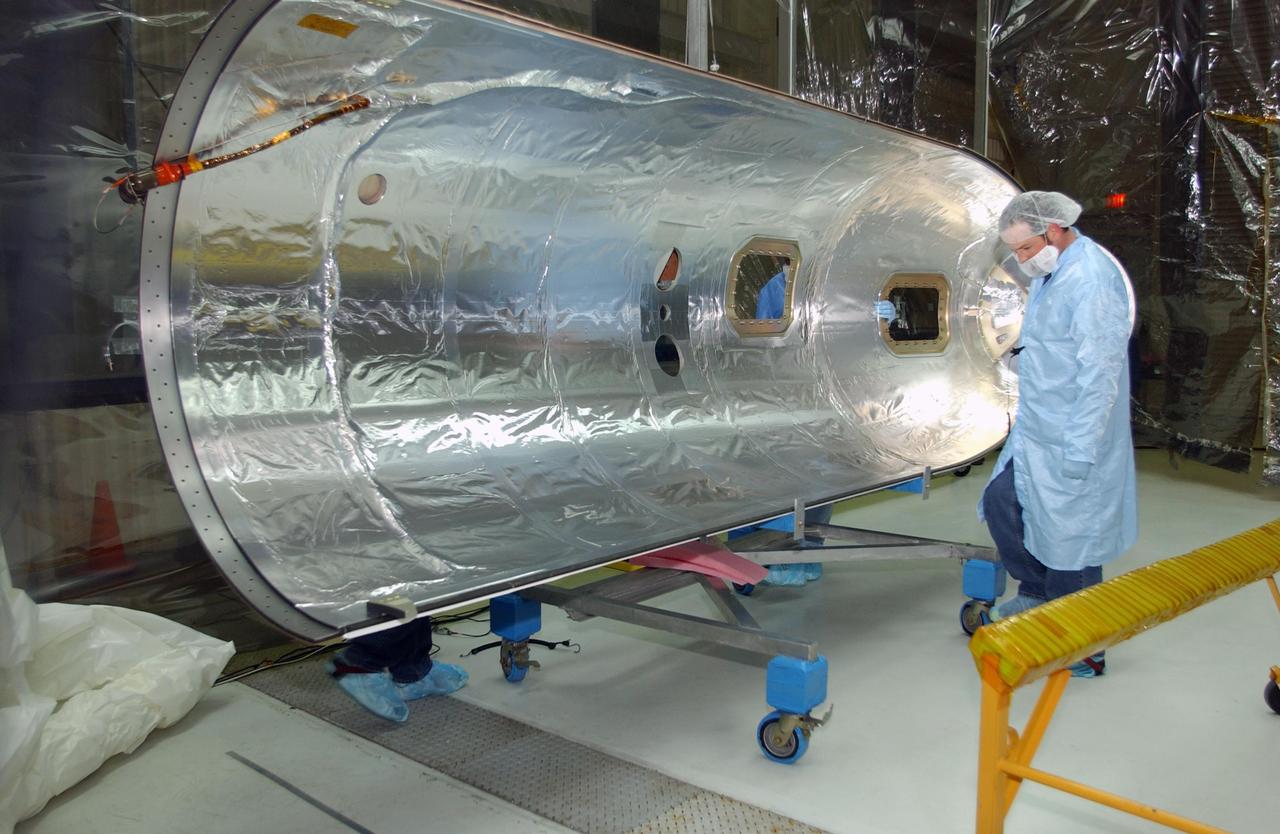 VANDENBERG AIR FORCE BASE, CALIF. - Inside Orbital Sciences’ Building 1555 at Vandenberg Air Force Base in California, workers clean and prepare the fairing to be installed around the Space Technology 5 (ST5) spacecraft.  The ST5 contains three microsatellites with miniaturized redundant components and technologies.  Each will validate New Millennium Program selected technologies, such as the Cold Gas Micro-Thruster and X-Band Transponder Communication System.  After deployment from the Pegasus, the micro-satellites will be positioned in a “string of pearls” constellation that demonstrates the ability to position them to perform simultaneous multi-point measurements of the magnetic field using highly sensitive magnetometers.  The data will help scientists understand and map the intensity and direction of the Earth’s magnetic field, its relation to space weather events, and affects on our planet.  With such missions, NASA hopes to improve scientists’ ability to accurately forecast space weather and minimize its harmful effects on space- and ground-based systems.  Launch of ST5 is scheduled from the belly of an L-1011 carrier aircraft no earlier than March 14 from Vandenberg Air Force Base.