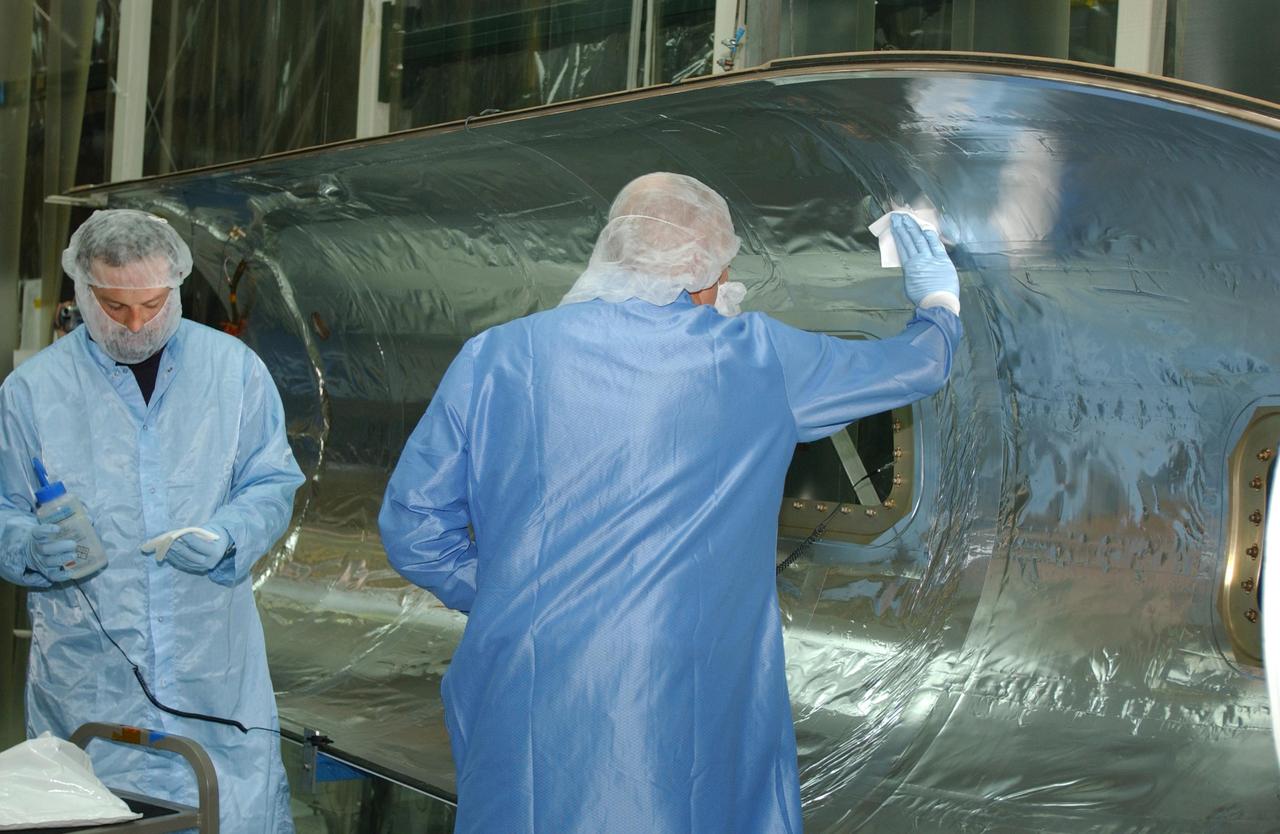 VANDENBERG AIR FORCE BASE, CALIF. - Inside Orbital Sciences’ Building 1555 at Vandenberg Air Force Base in California, workers clean and prepare the fairing to be installed around the Space Technology 5 (ST5) spacecraft.  The ST5 contains three microsatellites with miniaturized redundant components and technologies.  Each will validate New Millennium Program selected technologies, such as the Cold Gas Micro-Thruster and X-Band Transponder Communication System.  After deployment from the Pegasus, the micro-satellites will be positioned in a “string of pearls” constellation that demonstrates the ability to position them to perform simultaneous multi-point measurements of the magnetic field using highly sensitive magnetometers.  The data will help scientists understand and map the intensity and direction of the Earth’s magnetic field, its relation to space weather events, and affects on our planet.  With such missions, NASA hopes to improve scientists’ ability to accurately forecast space weather and minimize its harmful effects on space- and ground-based systems.  Launch of ST5 is scheduled from the belly of an L-1011 carrier aircraft no earlier than March 14 from Vandenberg Air Force Base.