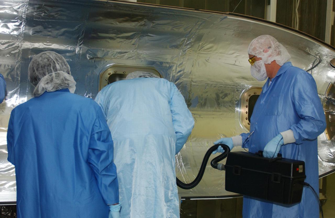 VANDENBERG AIR FORCE BASE, CALIF. - Inside Orbital Sciences’ Building 1555 at Vandenberg Air Force Base in California, workers clean and prepare the fairing to be installed around the Space Technology 5 (ST5) spacecraft.  The ST5 contains three microsatellites with miniaturized redundant components and technologies.   Each will validate New Millennium Program selected technologies, such as the Cold Gas Micro-Thruster and X-Band Transponder Communication System.  After deployment from the Pegasus, the micro-satellites will be positioned in a “string of pearls” constellation that demonstrates the ability to position them to perform simultaneous multi-point measurements of the magnetic field using highly sensitive magnetometers.  The data will help scientists understand and map the intensity and direction of the Earth’s magnetic field, its relation to space weather events, and affects on our planet.  With such missions, NASA hopes to improve scientists’ ability to accurately forecast space weather and minimize its harmful effects on space- and ground-based systems.  Launch of ST5 is scheduled from the belly of an L-1011 carrier aircraft no earlier than March 14 from Vandenberg Air Force Base.