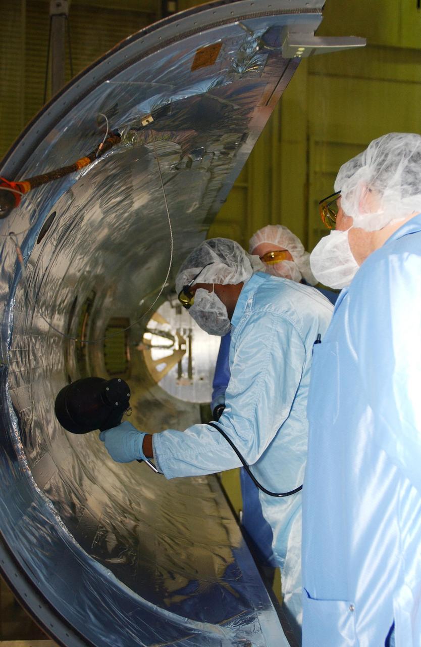 VANDENBERG AIR FORCE BASE, CALIF. - Inside Orbital Sciences’ Building 1555 at Vandenberg Air Force Base in California, workers clean and prepare the fairing to be installed around the Space Technology 5 (ST5) spacecraft.  The ST5 contains three microsatellites with miniaturized redundant components and technologies.  Each will validate New Millennium Program selected technologies, such as the Cold Gas Micro-Thruster and X-Band Transponder Communication System.  After deployment from the Pegasus, the micro-satellites will be positioned in a “string of pearls” constellation that demonstrates the ability to position them to perform simultaneous multi-point measurements of the magnetic field using highly sensitive magnetometers.  The data will help scientists understand and map the intensity and direction of the Earth’s magnetic field, its relation to space weather events, and affects on our planet.  With such missions, NASA hopes to improve scientists’ ability to accurately forecast space weather and minimize its harmful effects on space- and ground-based systems.  Launch of ST5 is scheduled from the belly of an L-1011 carrier aircraft no earlier than March 14 from Vandenberg Air Force Base.