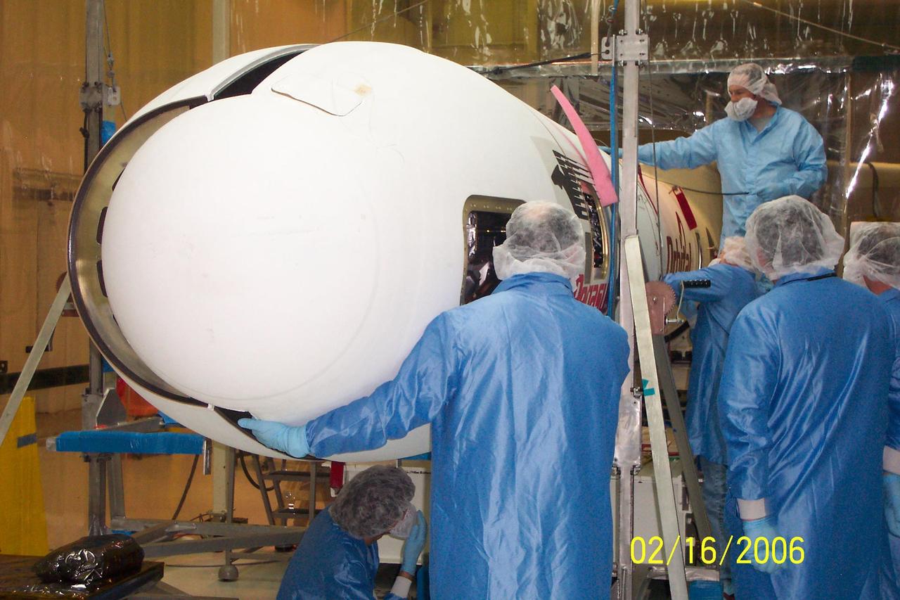 VANDENBERG AIR FORCE BASE, CALIF. - Inside Orbital Sciences’ Building 1555 at Vandenberg Air Force Base in California, workers position the second half of the fairing into place around the Space Technology 5 (ST5) spacecraft.  The ST5, which contains three microsatellites with miniaturized redundant components and technologies, is mated to its launch vehicle, Orbital Sciences' Pegasus XL.  Each of the ST5 microsatellites will validate New Millennium Program selected technologies, such as the Cold Gas Micro-Thruster and X-Band Transponder Communication System.  After deployment from the Pegasus, the micro-satellites will be positioned in a “string of pearls” constellation that demonstrates the ability to position them to perform simultaneous multi-point measurements of the magnetic field using highly sensitive magnetometers.  The data will help scientists understand and map the intensity and direction of the Earth’s magnetic field, its relation to space weather events, and affects on our planet.  Launch of ST5 and the Pegasus XL will be from underneath the belly of an L-1011 carrier aircraft on March 14 from Vandenberg Air Force Base.