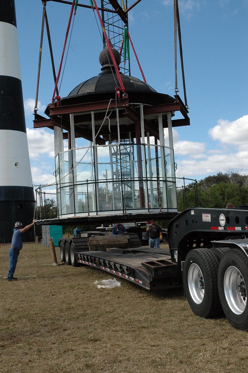KENNEDY SPACE CENTER, FLA.  - At Cape Canaveral Air Force Station,  workers help place the lamp room detached from the Cape Canaveral Lighthouse onto a flat bed truck.  It will be moved to a facility near Cape Canaveral for repairs and renovation. Leaks in the roof allowed moisture to seep in. The lamp room is being removed for repairs and refurbishment.  In addition, the original brass roof will be restored and put back in place. The Cape Canaveral Lighthouse is the only operational lighthouse owned by the Air Force. It was first erected in 1868 near the edge of the Atlantic Ocean.  Photo credit: NASA/Jack Pfaller