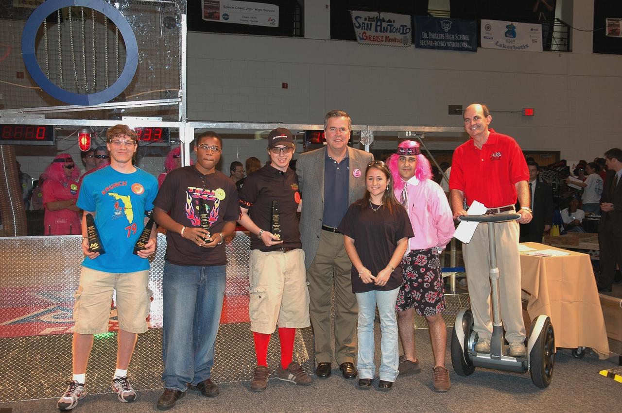 KENNEDY SPACE CENTER, FLA.  - During opening ceremonies of the  2006 FIRST Robotics Regional Competition held March 9-11 at the University of Central Florida in Orlando, Florida Governor Jeb Bush poses with recipients of the Governor's Award trophy.   The FIRST  Robotics Competition challenges teams of young people and their mentors to solve a common problem in a six-week timeframe using a standard "kit of parts" and a common set of rules. Teams build robots from the parts and enter them in a series of competitions.  FIRST, which is based on "For Inspiration and Recognition of Science and Technology," redefines winning for these students. Teams are rewarded for excellence in design, demonstrated team spirit, gracious professionalism and maturity, and ability to overcome obstacles. Scoring the most points is a secondary goal. Winning means building partnerships that last.  NASA and the University of Central Florida are co-sponsors of the regional event, which this year included more than 50 teams.  Photo credit: NASA/Kim Shiflett