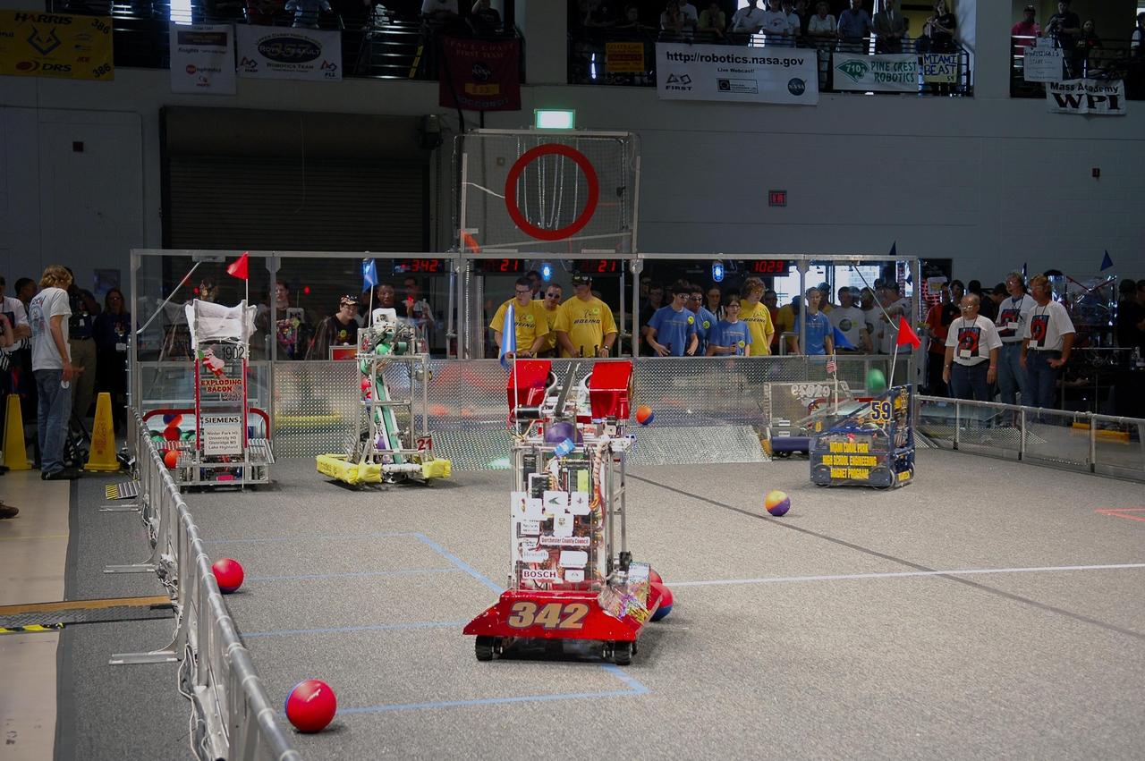 KENNEDY SPACE CENTER, FLA. - During the 2006 FIRST Robotics Regional Competition held March 9-11 at the University of Central Florida in Orlando, team robots are in pursuit of balls on the competition floor, which they must catch and throw into a goal. At least four teams in the competition were sponsored by KSC, NASA and contractors. The FIRST Robotics Competition challenges teams of young people and their mentors to solve a common problem in a six-week timeframe using a standard "kit of parts" and a common set of rules. Teams build robots from the parts and enter them in a series of competitions. FIRST, which is based on "For Inspiration and Recognition of Science and Technology," redefines winning for these students. Teams are rewarded for excellence in design, demonstrated team spirit, gracious professionalism and maturity, and ability to overcome obstacles. Scoring the most points is a secondary goal. Winning means building partnerships that last. NASA and the University of Central Florida are co-sponsors of the regional event, which this year included more than 50 teams. Photo credit: NASA/Kim Shiflett