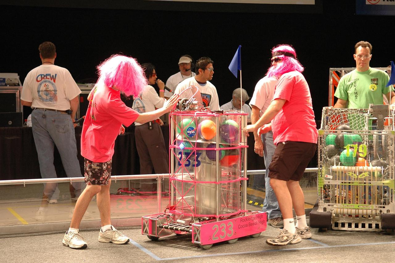 KENNEDY SPACE CENTER, FLA. - During the 2006 FIRST Robotics Regional Competition held March 9-11 at the University of Central Florida in Orlando, members of the "Pink Team" prepare their robot, Roccobot. The Pink Team comprises students from Rockledge High and Cocoa Beach High Schools and is co-sponsored by NASA KSC. The FIRST Robotics Competition challenges teams of young people and their mentors to solve a common problem in a six-week timeframe using a standard "kit of parts" and a common set of rules. Teams build robots from the parts and enter them in a series of competitions. FIRST, which is based on "For Inspiration and Recognition of Science and Technology," redefines winning for these students. Teams are rewarded for excellence in design, demonstrated team spirit, gracious professionalism and maturity, and ability to overcome obstacles. Scoring the most points is a secondary goal. Winning means building partnerships that last. NASA and the University of Central Florida are co-sponsors of the regional event, which this year included more than 50 teams. Photo credit: NASA/Kim Shiflett
