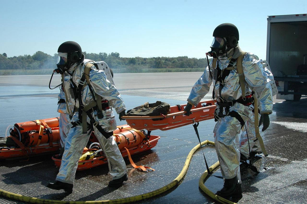 KENNEDY SPACE CENTER, FLA.  -  In a simulated emergency landing of a shuttle crew at NASA Kennedy Space Center's Shuttle Landing Facility, emergency rescue personnel aid an "astronaut" who just left the orbiter mockup.  Known as a Mode VI exercise, the operation uses volunteer workers from the Center to pose as astronauts. The purpose of the simulation is to exercise emergency preparedness personnel, equipment and facilities in rescuing astronauts from a downed orbiter and providing immediate medical attention. Photo credit: NASA/Kim Shiflett