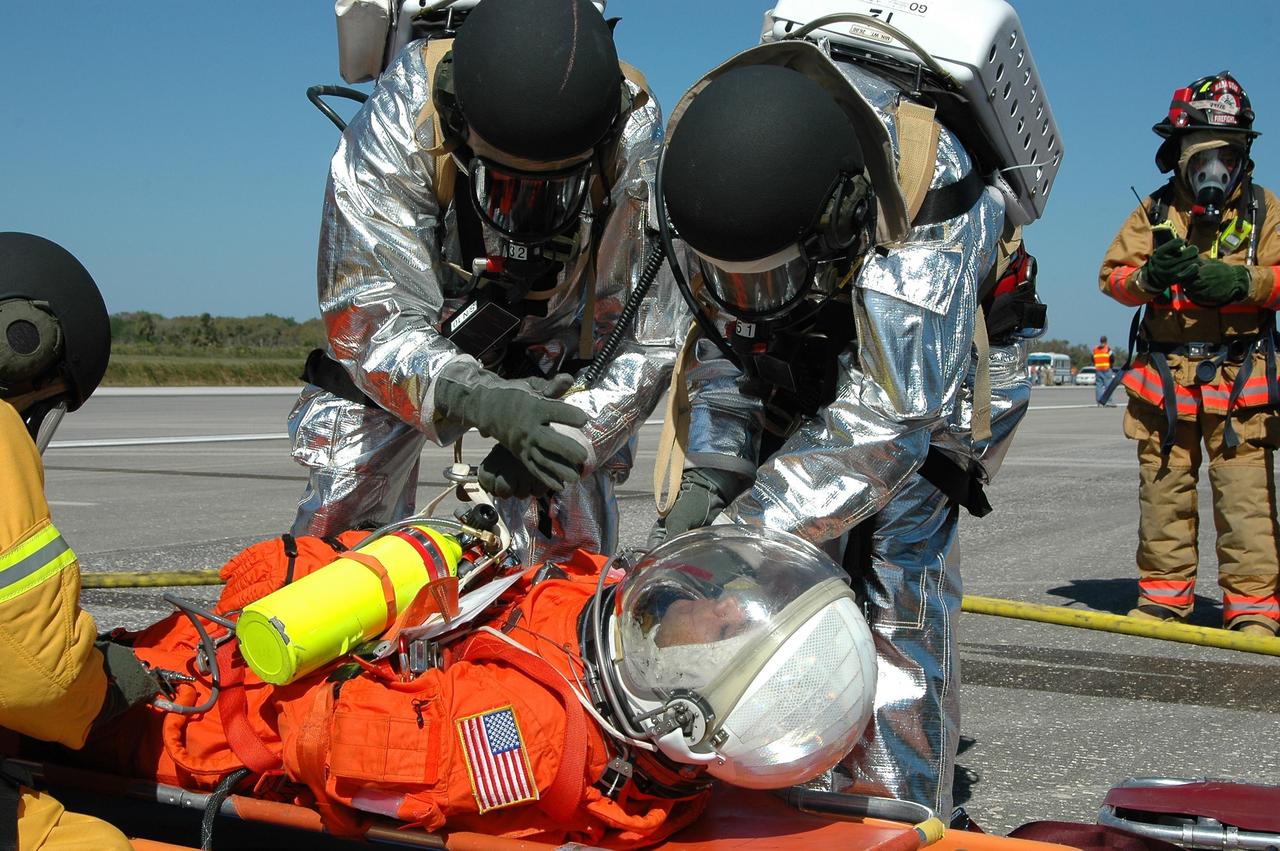 KENNEDY SPACE CENTER, FLA.  -  In a simulated emergency landing of a shuttle crew at NASA Kennedy Space Center's Shuttle Landing Facility, emergency rescue personnel tend to an "injured astronaut."   Known as a Mode VI exercise, the operation uses volunteer workers from the Center to pose as astronauts. The purpose of the simulation is to exercise emergency preparedness personnel, equipment and facilities in rescuing astronauts from a downed orbiter and providing immediate medical attention. Photo credit: NASA/Kim Shiflett
