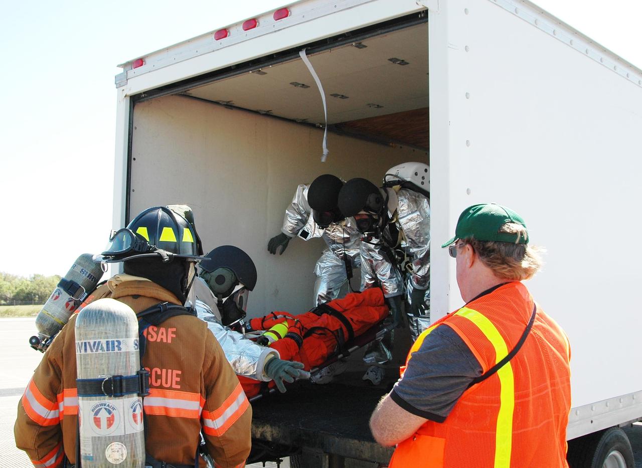 KENNEDY SPACE CENTER, FLA.  -   In a simulated emergency landing of a shuttle crew at NASA Kennedy Space Center's Shuttle Landing Facility, emergency rescue personnel place an "injured astronaut" into a rescue vehicle.  Known as a Mode VI exercise, the operation uses volunteer workers from the Center to pose as astronauts. The purpose of the simulation is to exercise emergency preparedness personnel, equipment and facilities in rescuing astronauts from a downed orbiter and providing immediate medical attention. Photo credit: NASA/Kim Shiflett