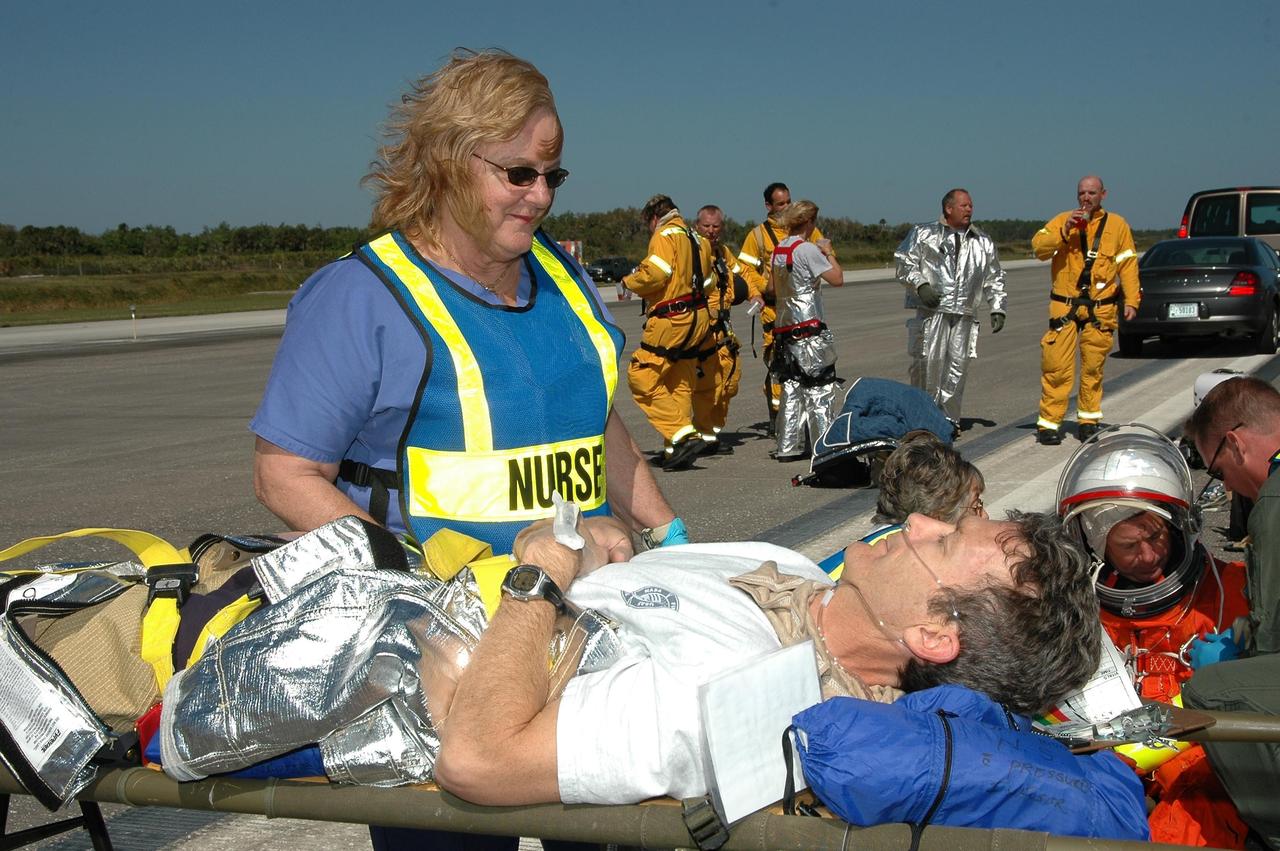KENNEDY SPACE CENTER, FLA.  -  At NASA Kennedy Space Center's Shuttle Landing Facility, emergency personnel tend to "injured astronauts" during a simulated emergency landing of a shuttle crew.  Known as a Mode VI exercise, the operation uses volunteer workers from the Center to pose as astronauts. The purpose of the simulation is to exercise emergency preparedness personnel, equipment and facilities in rescuing astronauts from a downed orbiter and providing immediate medical attention. Photo credit: NASA/Kim Shiflett