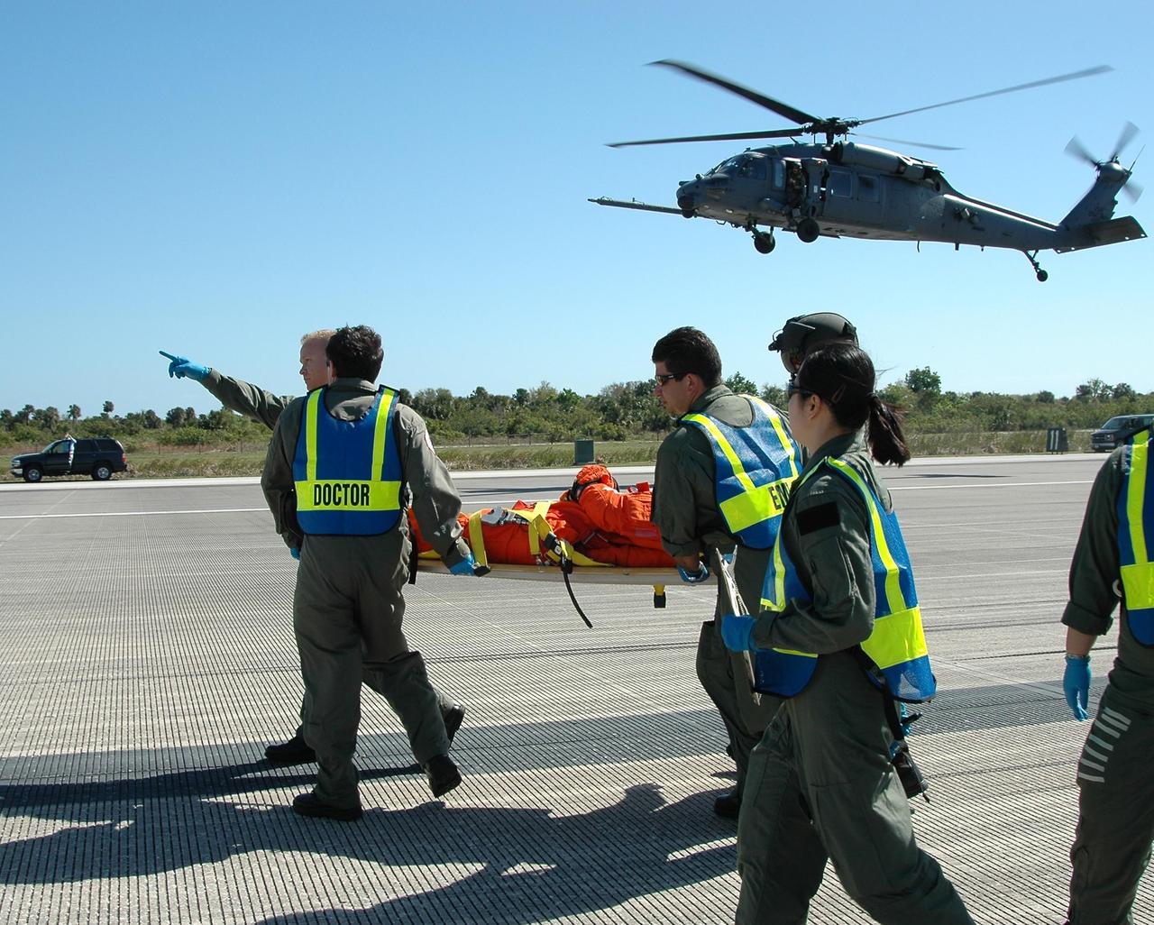 KENNEDY SPACE CENTER, FLA.  -  During a simulated emergency landing of a shuttle crew at NASA Kennedy Space Center's Shuttle Landing Facility, emergency rescue personnel carry an "injured astronaut" to a waiting helicopter.  Known as a Mode VI exercise, the operation uses volunteer workers from the Center to pose as astronauts. The purpose of the simulation is to exercise emergency preparedness personnel, equipment and facilities in rescuing astronauts from a downed orbiter and providing immediate medical attention. Photo credit: NASA/Kim Shiflett
