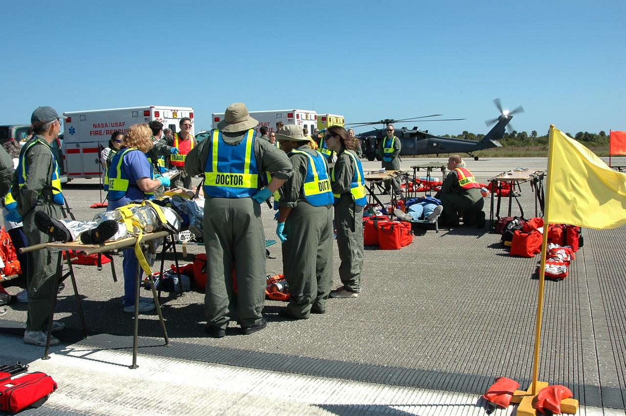 KENNEDY SPACE CENTER, FLA.  -  At NASA Kennedy Space Center's Shuttle Landing Facility, emergency personnel tend to "injured astronauts" during a simulated emergency landing of a shuttle crew.  Known as a Mode VI exercise, the operation uses volunteer workers from the Center to pose as astronauts. The purpose of the simulation is to exercise emergency preparedness personnel, equipment and facilities in rescuing astronauts from a downed orbiter and providing immediate medical attention. Photo credit: NASA/Kim Shiflett