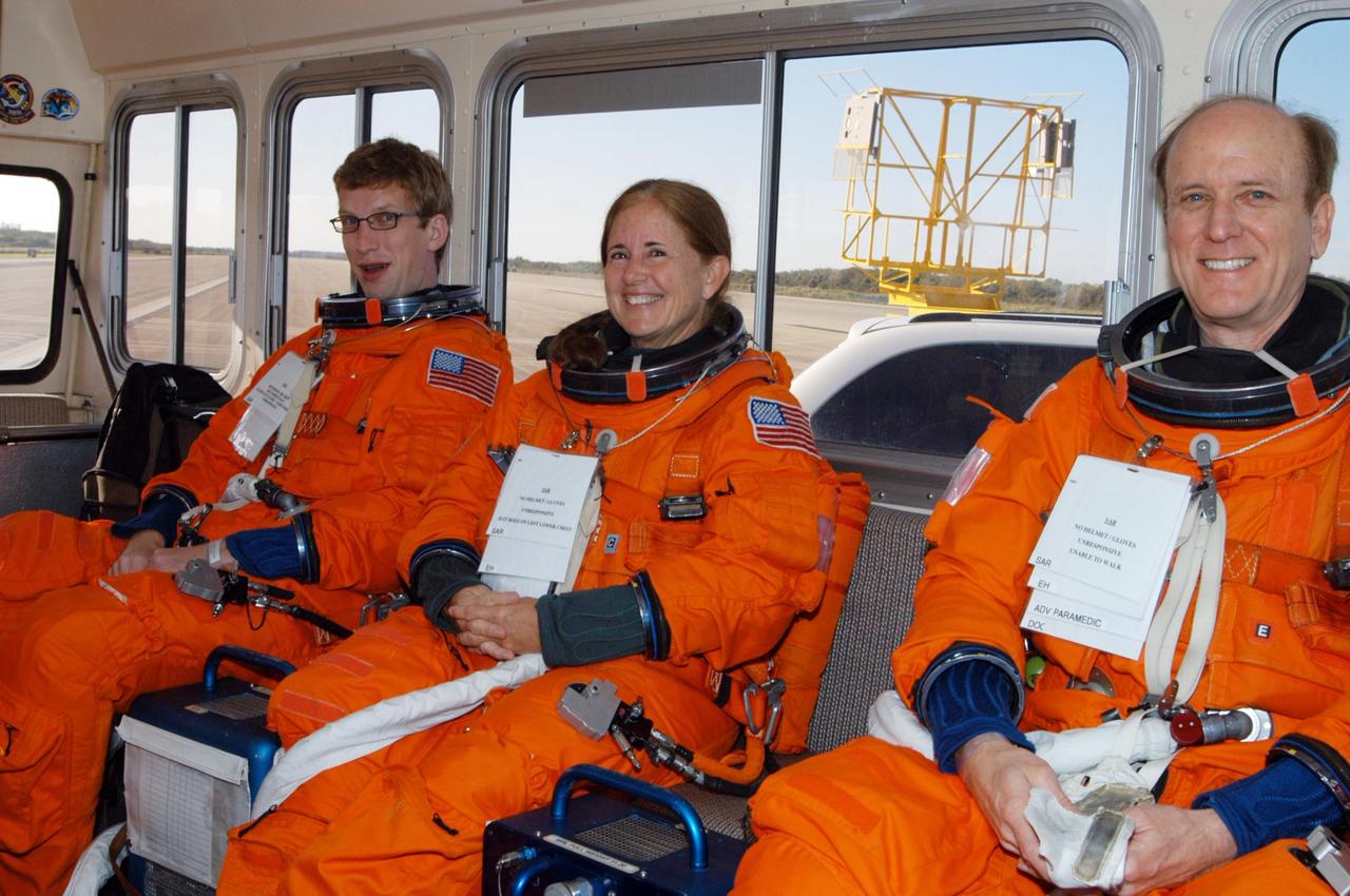KENNEDY SPACE CENTER, FLA.  -   Workers at NASA's Kennedy Space Center pose as astronauts during a simulated emergency landing of a shuttle crew.  From left are Charlie Plain, with InDyne Inc.; Debbie Awtonomow, with NASA; and Brian Bateman, with United Space Alliance.  Known as a Mode VI exercise, the operation uses volunteer workers from the Center to pose as astronauts. The purpose of the simulation is to exercise emergency preparedness personnel, equipment and facilities in rescuing astronauts from a downed orbiter and providing immediate medical attention. Photo credit: NASA/George Shelton