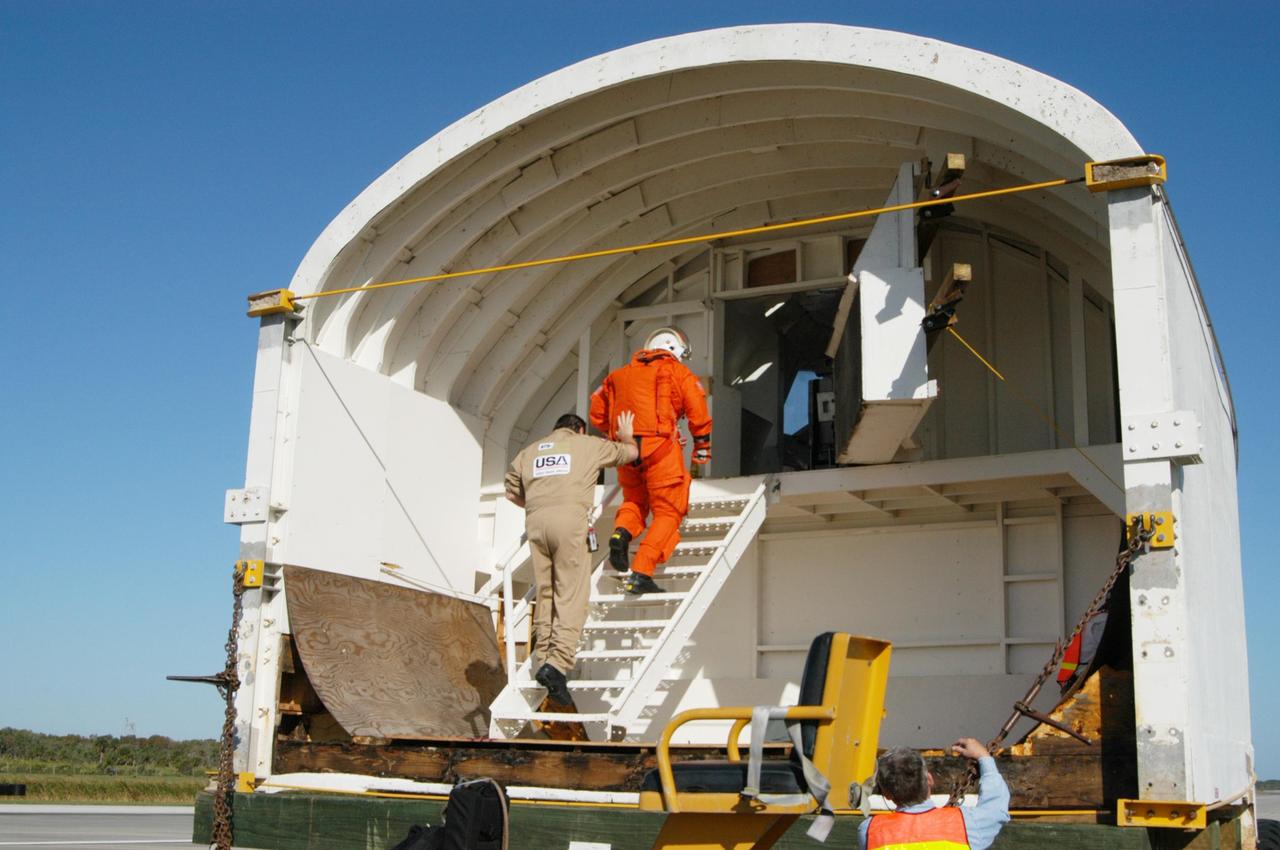 KENNEDY SPACE CENTER, FLA.  -   Workers at NASA's Kennedy Space Center enter the orbiter mockup in preparation for a simulated emergency landing of a shuttle crew.  Known as a Mode VI exercise, the operation uses volunteer workers from the Center to pose as astronauts. The purpose of the simulation is to exercise emergency preparedness personnel, equipment and facilities in rescuing astronauts from a downed orbiter and providing immediate medical attention. Photo credit: NASA/George Shelton