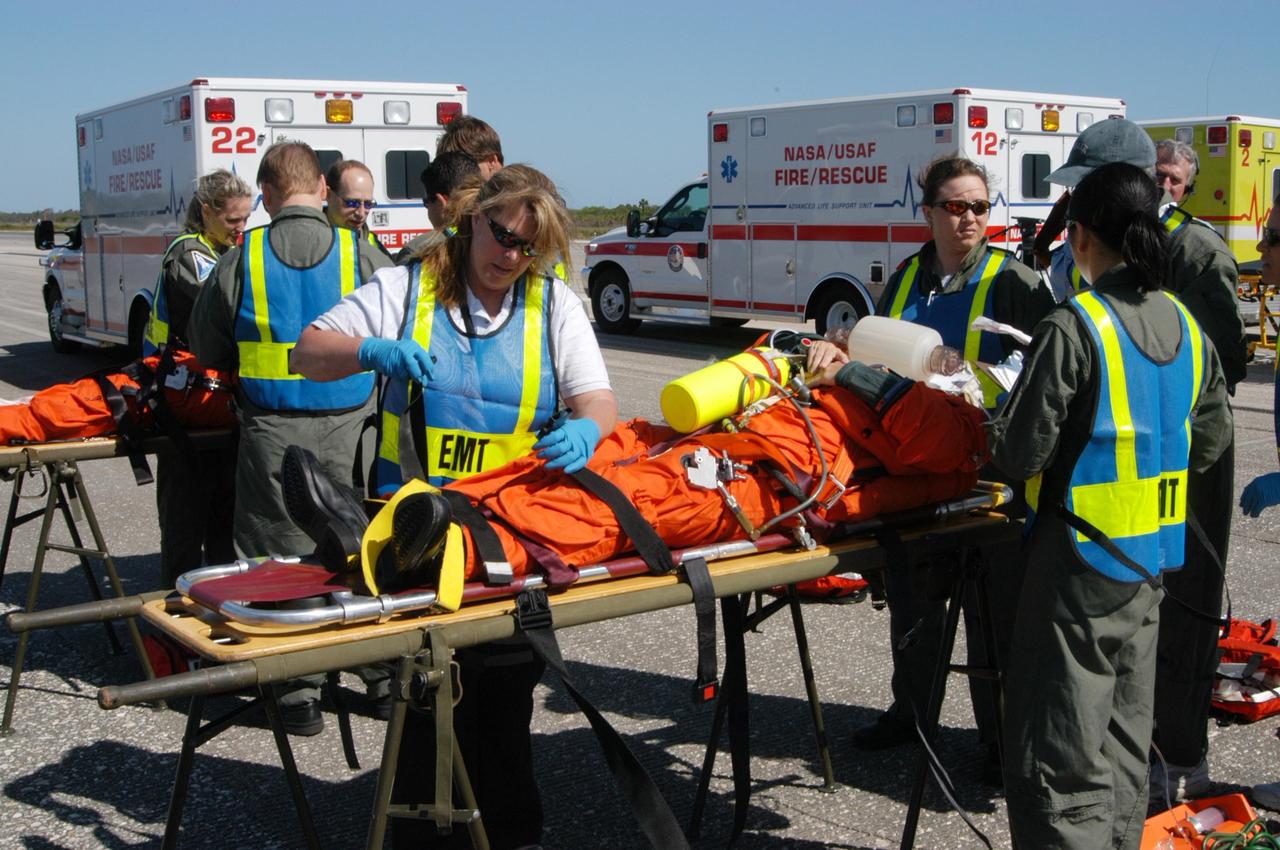 KENNEDY SPACE CENTER, FLA.  -   At NASA Kennedy Space Center's Shuttle Landing Facility, emergency personnel tend to "injured astronauts" during a simulated emergency landing of a shuttle crew.  Known as a Mode VI exercise, the operation uses volunteer workers from the Center to pose as astronauts. The purpose of the simulation is to exercise emergency preparedness personnel, equipment and facilities in rescuing astronauts from a downed orbiter and providing immediate medical attention. Photo credit: NASA/George Shelton