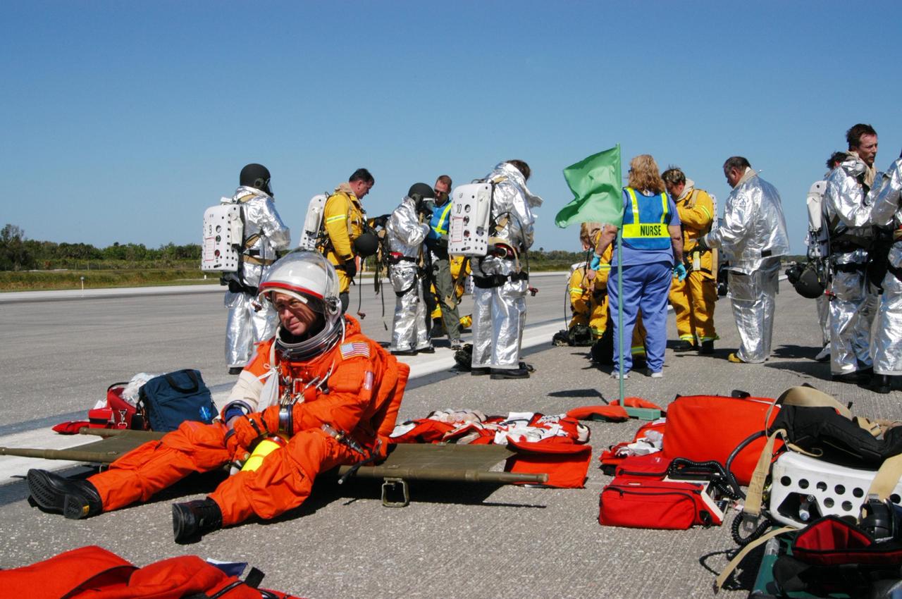 KENNEDY SPACE CENTER, FLA.  -   At NASA Kennedy Space Center's Shuttle Landing Facility, emergency personnel tend to "injured astronauts" during a simulated emergency landing of a shuttle crew.  Known as a Mode VI exercise, the operation uses volunteer workers from the Center to pose as astronauts. The purpose of the simulation is to exercise emergency preparedness personnel, equipment and facilities in rescuing astronauts from a downed orbiter and providing immediate medical attention. Photo credit: NASA/George Shelton