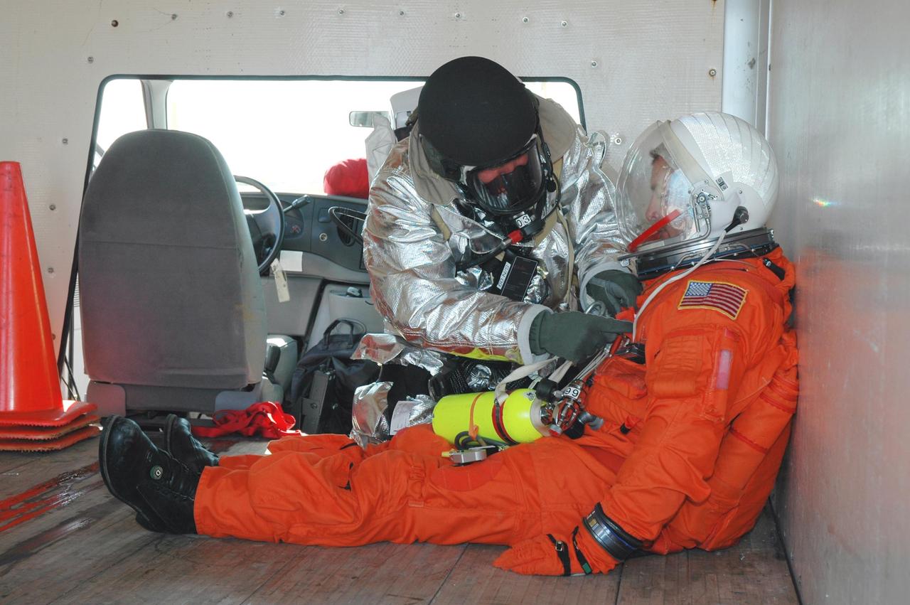 KENNEDY SPACE CENTER, FLA.  -  At NASA Kennedy Space Center's Shuttle Landing Facility, emergency personnel tends to an "injured astronaut" inside a rescue vehicle during a simulated emergency landing of a shuttle crew.  Known as a Mode VI exercise, the operation uses volunteer workers from the Center to pose as astronauts. The purpose of the simulation is to exercise emergency preparedness personnel, equipment and facilities in rescuing astronauts from a downed orbiter and providing immediate medical attention. Photo credit: NASA/Jim Grossmann