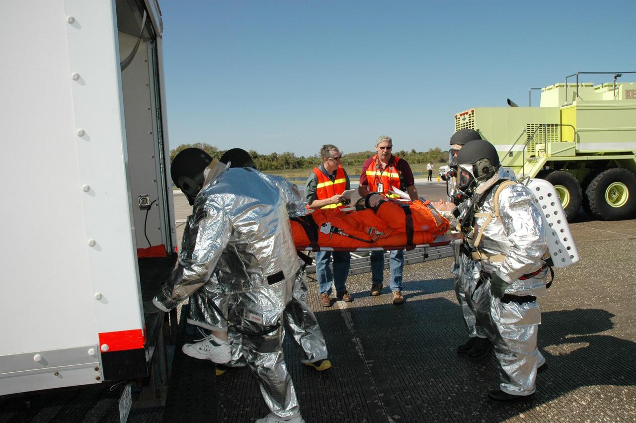 KENNEDY SPACE CENTER, FLA.  -  At NASA Kennedy Space Center's Shuttle Landing Facility, emergency personnel carry an "injured astronaut" to a rescue vehicle during a simulated emergency landing of a shuttle crew.  Known as a Mode VI exercise, the operation uses volunteer workers from the Center to pose as astronauts. The purpose of the simulation is to exercise emergency preparedness personnel, equipment and facilities in rescuing astronauts from a downed orbiter and providing immediate medical attention. Photo credit: NASA/Jim Grossmann