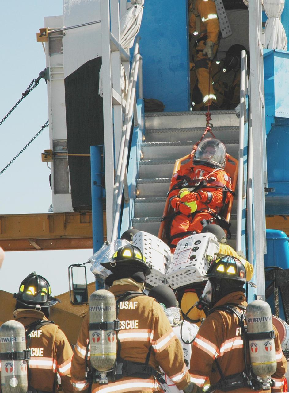 KENNEDY SPACE CENTER, FLA.  -  At NASA Kennedy Space Center's Shuttle Landing Facility, emergency personnel lower an "injured astronaut" on a stretcher down the stairs of the orbiter mockup.  Volunteers and emergency rescue workers are participating in a simulated emergency landing of a shuttle crew. Known as a Mode VI exercise, the operation uses volunteer workers from the Center to pose as astronauts. The purpose of the simulation is to exercise emergency preparedness personnel, equipment and facilities in rescuing astronauts from a downed orbiter and providing immediate medical attention. Photo credit: NASA/Jim Grossmann