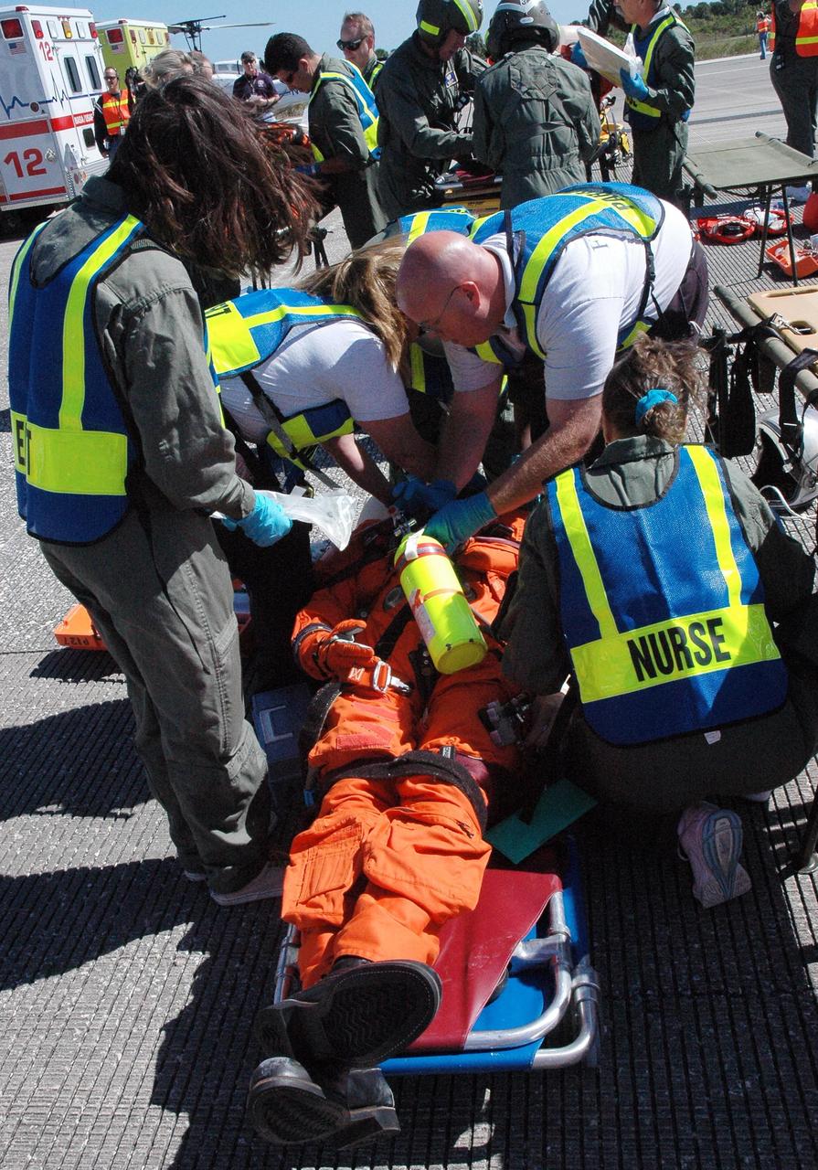 KENNEDY SPACE CENTER, FLA.  -  At NASA Kennedy Space Center's Shuttle Landing Facility, emergency rescue worker tend to "injured astronauts" during a simulated emergency landing of a shuttle crew.   Known as a Mode VI exercise, the operation uses volunteer workers from the Center to pose as astronauts. The purpose of the simulation is to exercise emergency preparedness personnel, equipment and facilities in rescuing astronauts from a downed orbiter and providing immediate medical attention. Photo credit: NASA/Troy Cryder