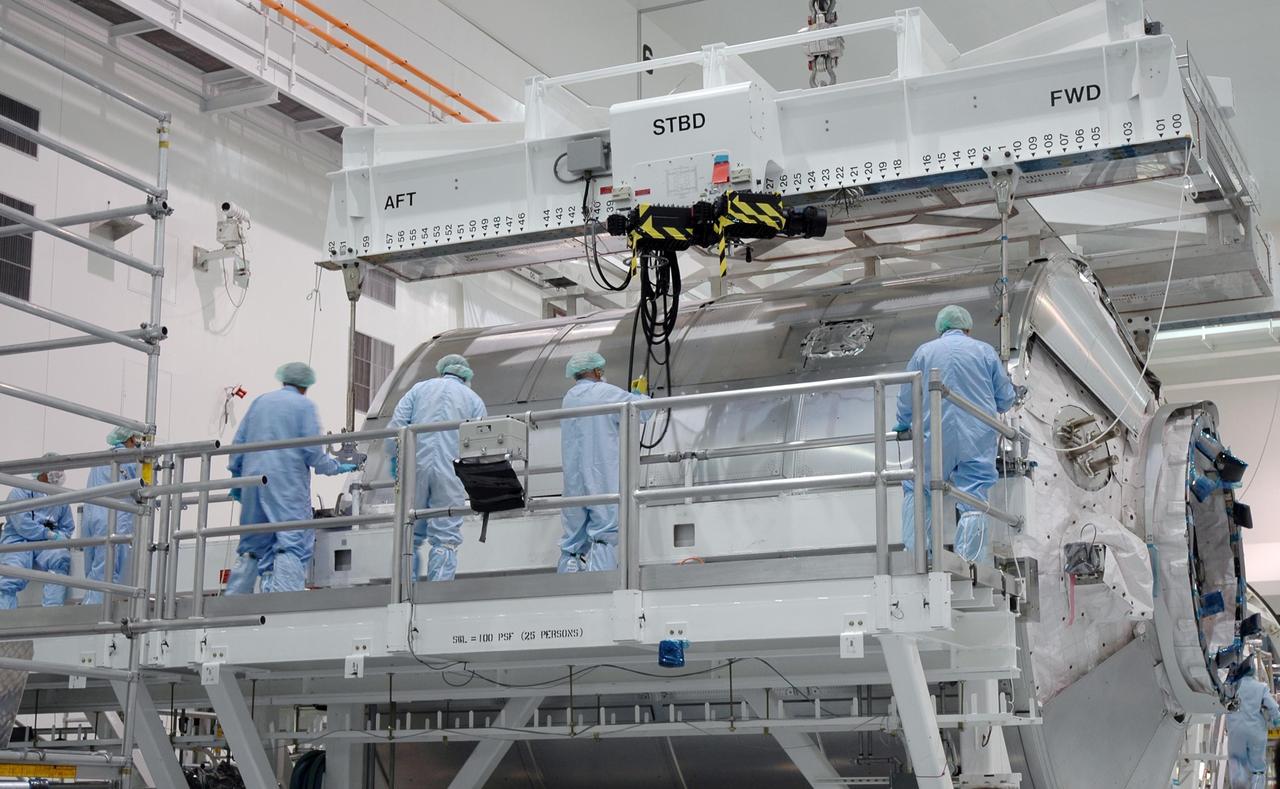 KENNEDY SPACE CENTER, FLA.  -   In NASA Kennedy Space Center's Space Station Processing Facility (SSPF), workers attach an overhead crane to the multi-purpose logistics module Donatello in order to move it to a payload canister.   Donatello is being transferred to the Operations and Checkout Building to make room in the SSPF for the arrival of elements for future flights from other ISS partners. Photo credit: NASA/Jim Grossmann