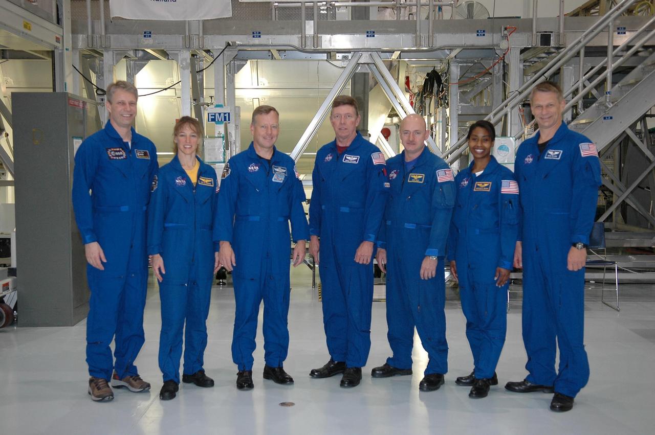 KENNEDY SPACE CENTER, FLA. - The crew for mission STS-121 is taking part in a Crew Equipment Interface Test (CEIT) inside the Space Station Processing Facility at NASA's Kennedy Space Center. Standing in front of a work stand are, left to right, Mission Specialists Thomas Reiter and Lisa Nowak, Mission Commander Steven Lindsey, Mission Specialist Michael Fossum, Pilot Mark Kelly, and Mission Specialists Stephanie Wilson and Piers Sellers. Reiter represents the European Space Agency (ESA) and will remain on the space station working with the station crew under a contract between ESA and the Russian Federal Space Agency. He will return to Earth aboard STS-116 or a Russian Soyuz. A CEIT provides hands-on experiences with equipment used on-orbit. Mission STS-121 is the second in the Return to Flight sequence and will carry on improvements that debuted during last year's STS-114 mission and build upon those tests. Launch is scheduled in July. Photo credit: NASA/Kim Shiflett