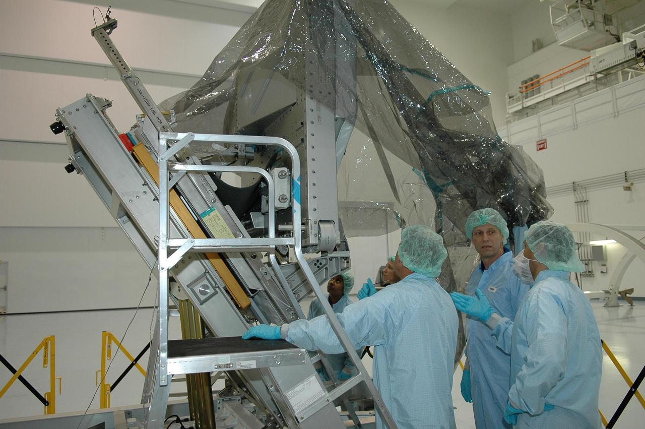 KENNEDY SPACE CENTER, FLA.  -   The crew for mission STS-121 is taking part in a Crew Equipment Interface Test (CEIT) inside the Space Station Processing Facility at NASA's Kennedy Space Center.  Looking at the trailing umbilical system reel assembly that will be installed on the International Space Station are Mission Specialists Michael Fossum (on ladder), Lisa Nowak and Stephanie Wilson (below Fossum on floor).  A CEIT provides hands-on experiences with equipment used on-orbit.  Mission STS-121 is the second in the Return to Flight sequence and will carry on improvements that debuted during last year's STS-114 mission and build upon those tests.  Launch is scheduled in July.  Photo credit: NASA/Kim Shiflett
