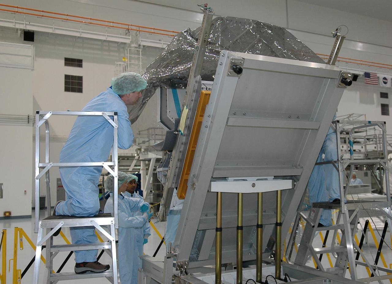 KENNEDY SPACE CENTER, FLA.  -   Members of the crew for mission STS-121 look at the trailing umbilical system reel assembly that will be installed on the International Space Station during the mission.  Seen here are Mission Specialists Stephanie Wilson and Lisa Nowak (background) and Michael Fossum (center front). The crew is taking part in a Crew Equipment Interface Test (CEIT) inside the Space Station Processing Facility at NASA's Kennedy Space Center.   A CEIT provides hands-on experiences with equipment used on-orbit.  Mission STS-121 is the second in the Return to Flight sequence and will carry on improvements that debuted during last year's STS-114 mission and build upon those tests.  Launch is scheduled in July.  Photo credit: NASA/Kim Shiflett