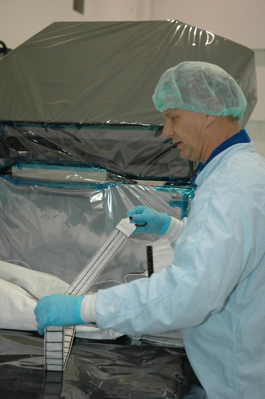 KENNEDY SPACE CENTER, FLA.  -   During a Crew Equipment Interface Test (CEIT) inside the Space Station Processing Facility at NASA's Kennedy Space Center, STS-121 Mission Specialist Piers Sellers works with a strap on the trailing umbilical system reel assembly that will be installed on the International Space Station during their mission.  A CEIT provides hands-on experiences with equipment used on-orbit.  Mission STS-121 is the second in the Return to Flight sequence and will carry on improvements that debuted during last year's STS-114 mission and build upon those tests.  Launch is scheduled in July.  Photo credit: NASA/Kim Shiflett