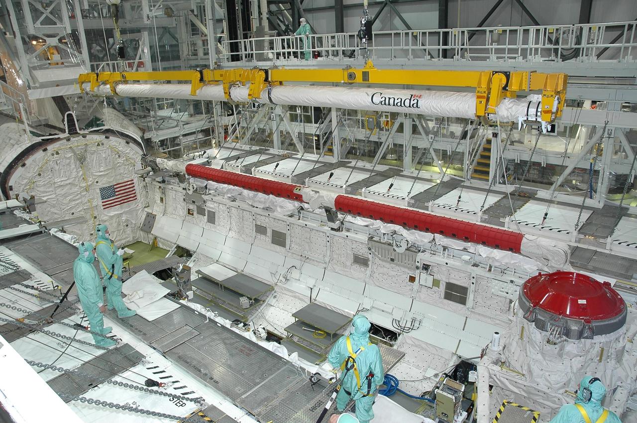KENNEDY SPACE CENTER, FLA. -  In Orbiter Processing Facility bay 1 at NASA's Kennedy Space Center, the orbiter boom sensor system is lowered into Atlantis' payload bay for installation.  The 50-foot-long boom attaches to the shuttle arm and is one of the new safety measures added prior to Return to Flight last year. It equips the orbiter with cameras and laser systems to inspect the shuttle's heat shield while in space.  Atlantis is scheduled to launch on mission STS-115 no earlier than Aug. 28.  Photo credit: NASA/Jim Grossmann