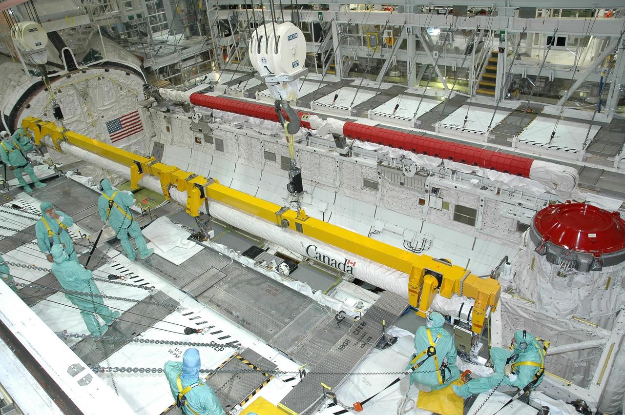 KENNEDY SPACE CENTER, FLA. -  In Orbiter Processing Facility bay 1 at NASA's Kennedy Space Center, workers complete installation of the orbiter boom sensor system into Atlantis' payload bay. The 50-foot-long boom attaches to the shuttle arm and is one of the new safety measures added prior to Return to Flight last year. It equips the orbiter with cameras and laser systems to inspect the shuttle's heat shield while in space.  Atlantis is scheduled to launch on mission STS-115 no earlier than Aug. 28.  Photo credit: NASA/Jim Grossmann