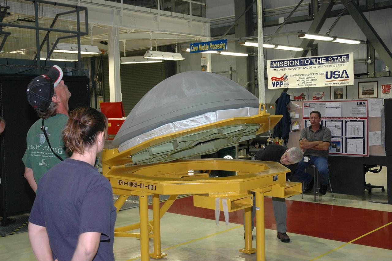 KENNEDY SPACE CENTER, FLA. -   In Orbiter Processing Facility bay 2 at NASA's Kennedy Space Center, workers are nearby as a crane lifts the reinforced carbon-carbon nose cap to be installed onto Endeavour.  The nose cap is insulated with thermal protection system blankets made of a woven ceramic fabric.  The special blankets help insulate the vehicle's nose cap and protect it from the extreme temperatures it will face during a mission. Photo credit: NASA/Jim Grossmann
