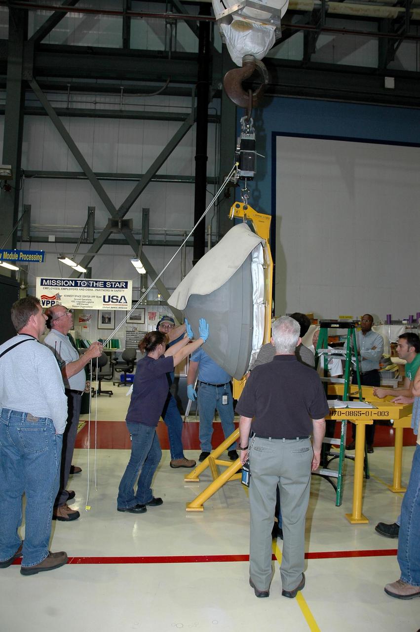 KENNEDY SPACE CENTER, FLA. - In Orbiter Processing Facility bay 2 at NASA's Kennedy Space Center, workers maneuver the reinforced carbon-carbon nose cap as it is hoisted into the air. The nose cap will be installed on Endeavour. The nose cap is insulated with thermal protection system blankets made of a woven ceramic fabric. The special blankets help insulate the vehicle's nose cap and protect it from the extreme temperatures it will face during a mission. Photo credit: NASA/Jim Grossmann