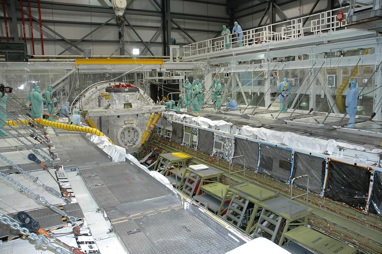 KENNEDY SPACE CENTER, FLA. - In Orbiter Processing Facility bay 2 at NASA's Kennedy Space Center, the airlock has been lowered into place for installation into Endeavour's payload bay. The airlock is located in the middeck. The airlock and airlock hatches permit flight crew members to transfer from the middeck crew compartment into the payload bay for extravehicular activities in their space suits without depressurizing the orbiter crew cabin. The airlock is sized to accommodate two fully suited flight crew members simultaneously. Photo credit: NASA/Jim Grossmann