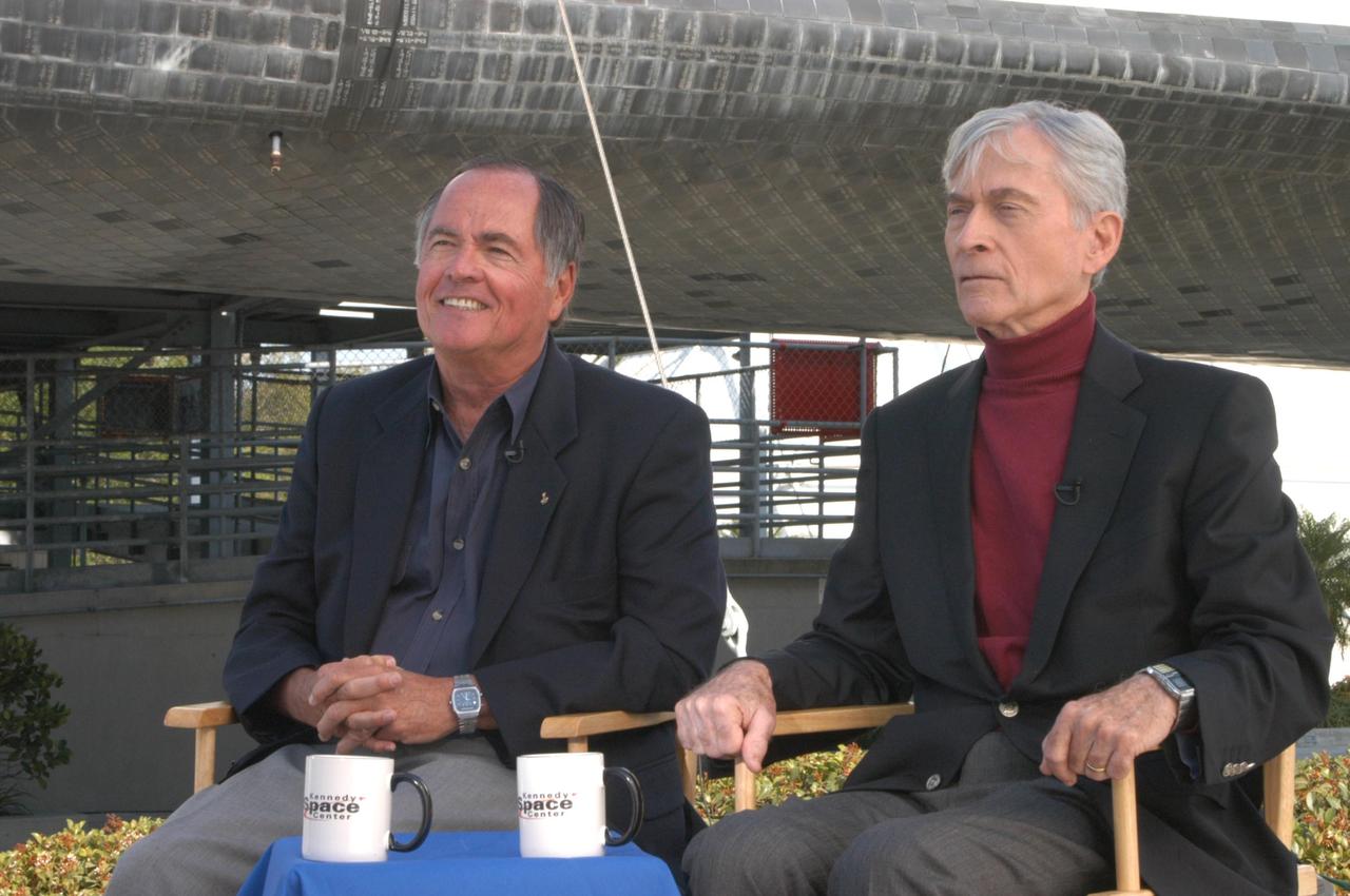 KENNEDY SPACE CENTER, FLA. - To honor the 25th anniversary of the first shuttle launch on April 12, 1981, STS-1 Pilot Bob Crippen (left) and Commander John Young (right) sit in front of a mockup of a space shuttle at the Kennedy Space Center Visitor Complex. During their appearance, they shared their experiences on that historic flight. Photo credit: NASA/George Shelton