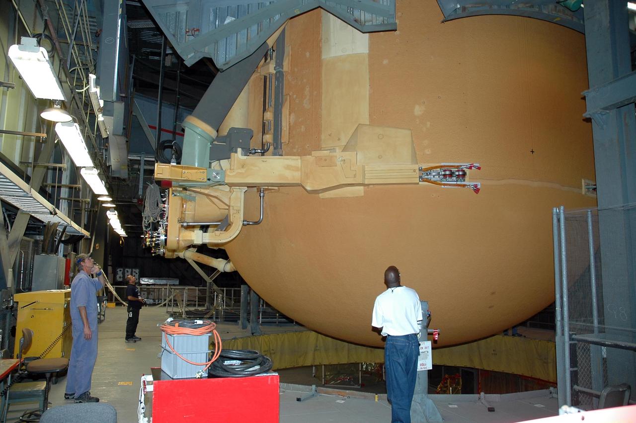 KENNEDY SPACE CENTER, FLA.  -  Inside the Vehicle Assembly Building at NASA's Kennedy Space Center, external tank number 119 is being lifted from the checkout cell and will be placed horizontally on the transporter in the transfer aisle. Once in the transfer aisle, technicians will reapply the thermal protection system foam that was removed in order to replace the tank's four liquid hydrogen engine cutoff sensors. The tank is being prepared to launch Space Shuttle Discovery on mission STS-121 in July.