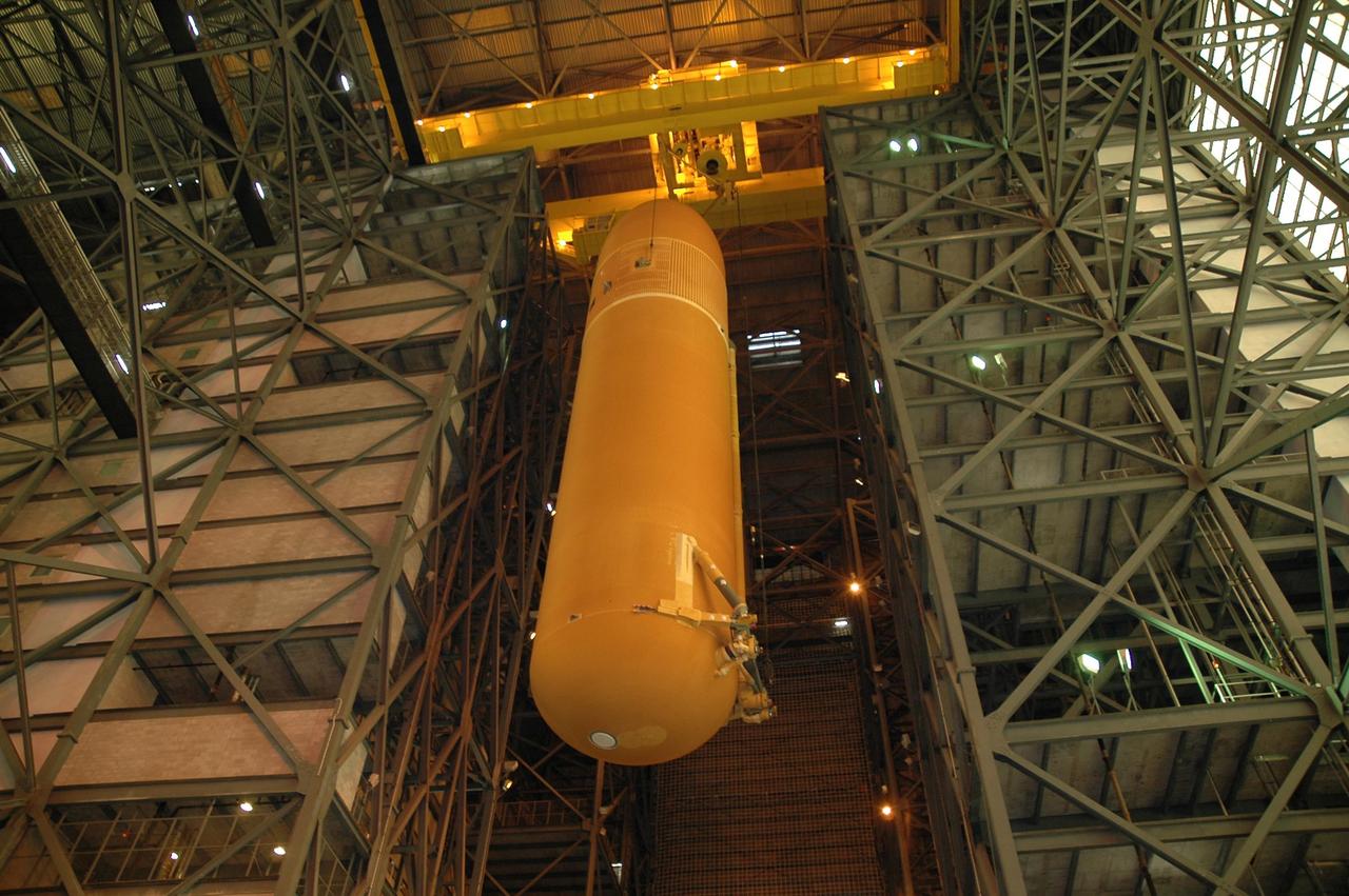 KENNEDY SPACE CENTER, FLA.  -  Inside the Vehicle Assembly Building at NASA's Kennedy Space Center, external tank number 119 is being lowered toward the floor of the transfer aisle.  It will be placed horizontally on a transporter where technicians will reapply the thermal protection system foam that was removed in order to replace the tank's four liquid hydrogen engine cutoff sensors. The tank is being prepared to launch Space Shuttle Discovery on mission STS-121 in July.  Photo credit: NASA/Cory Huston
