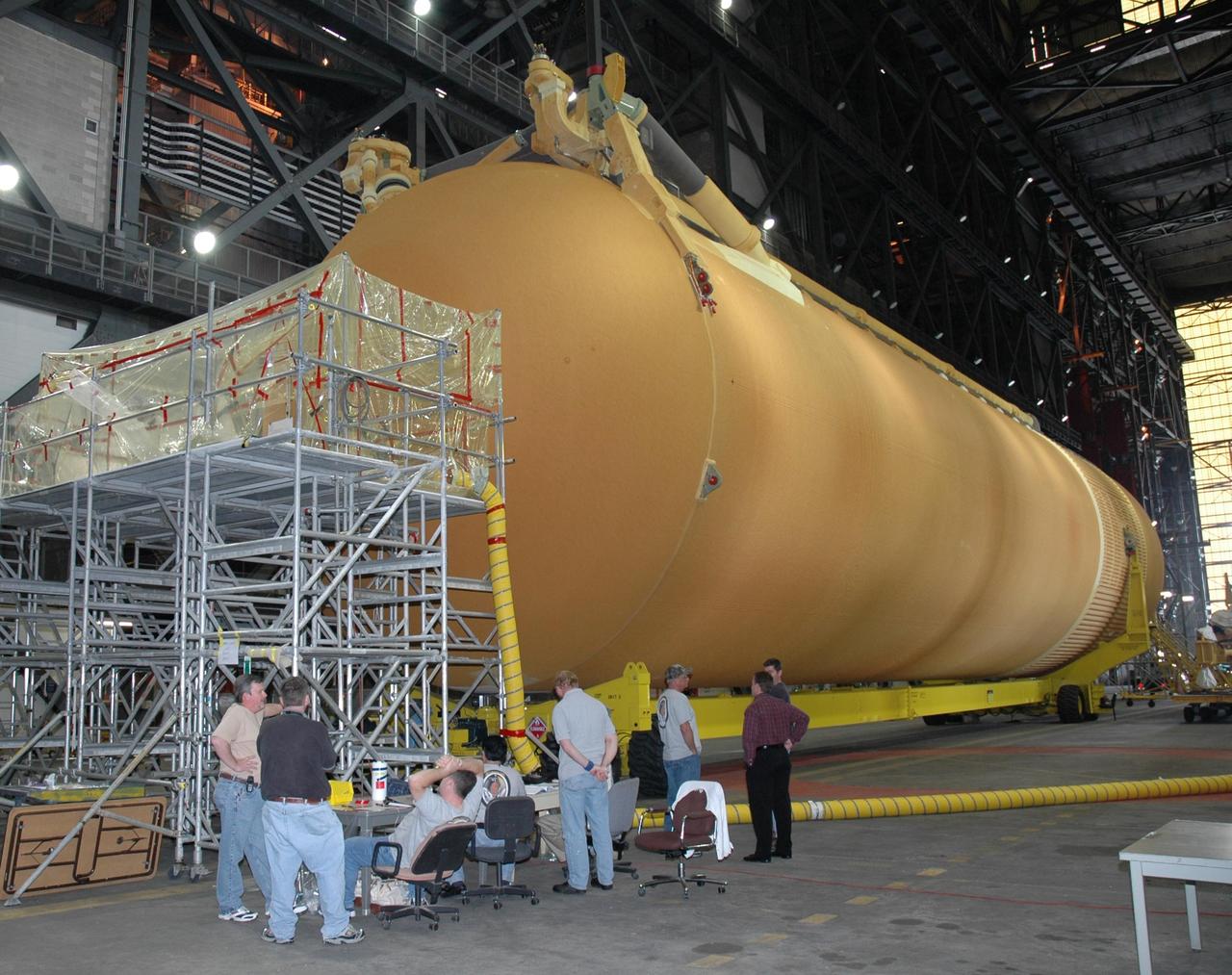 KENNEDY SPACE CENTER, FLA.  -  In the transfer aisle of the Vehicle Assembly Building, a stand is prepared from which workers will refoam the cover, called the "manhole," on the bottom of external tank number 119.   The manhole was removed to access the area where the tank's four liquid hydrogen engine cutoff sensors were replaced. The tank is being prepared to launch Space Shuttle Discovery on mission STS-121 in July.  Photo credit: NASA/Jim Grossmann