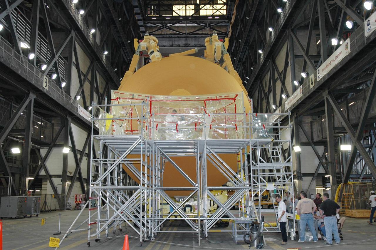 KENNEDY SPACE CENTER, FLA. - In the transfer aisle of the Vehicle Assembly Building, a stand is ready for workers to refoam the cover, called the "manhole," on the bottom of external tank number 119. The manhole was removed to access the area where the tank's four liquid hydrogen engine cutoff sensors were replaced. The tank is being prepared to launch Space Shuttle Discovery on mission STS-121 in July. Photo credit: NASA/Jim Grossmann The tank is being prepared to launch Space Shuttle Discovery on mission STS-121 in July. Photo credit: NASA/Jim Grossmann