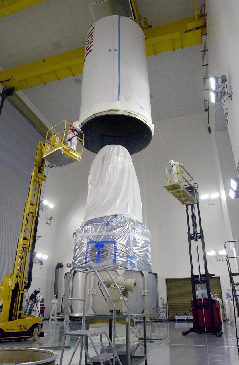 VANDENBERG AIR FORCE BASE, Calif. - Inside the Astrotech Payload Processing Facility on Vandenberg Air Force Base in California, the transport canister is lowered toward the covered dual spacecraft CALIPSO and CloudSat below. Once inside the canister, the spacecraft will be moved to Space Launch Complex 2. There the spacecraft will be lifted and mated with a Boeing Delta II rocket for launch on April 21. CALIPSO stands for Cloud-Aerosol Lidar and Infrared Pathfinder Satellite Observation. It will fly in combination with the CloudSat satellite to provide never-before-seen 3-D perspectives of how clouds and aerosols form, evolve, and affect weather and climate. CALIPSO and CloudSat will join three other satellites in orbit to enhance understanding of climate systems.