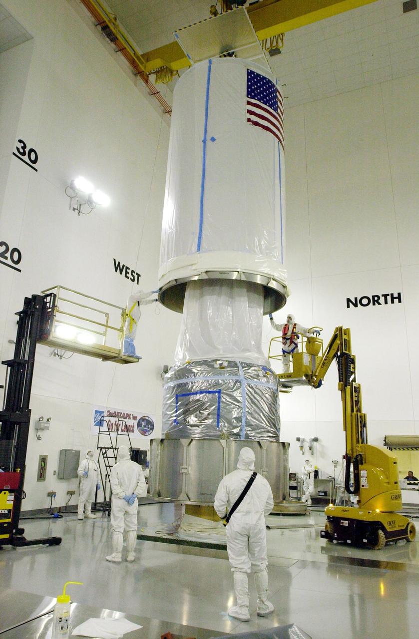 VANDENBERG AIR FORCE BASE, Calif. - Inside the Astrotech Payload Processing Facility on Vandenberg Air Force Base in California, the transport canister is lowered over the covered dual spacecraft CALIPSO and CloudSat below. Once inside the canister, the spacecraft will be moved to Space Launch Complex 2. There the spacecraft will be lifted and mated with a Boeing Delta II rocket for launch on April 21. CALIPSO stands for Cloud-Aerosol Lidar and Infrared Pathfinder Satellite Observation. It will fly in combination with the CloudSat satellite to provide never-before-seen 3-D perspectives of how clouds and aerosols form, evolve, and affect weather and climate. CALIPSO and CloudSat will join three other satellites in orbit to enhance understanding of climate systems.