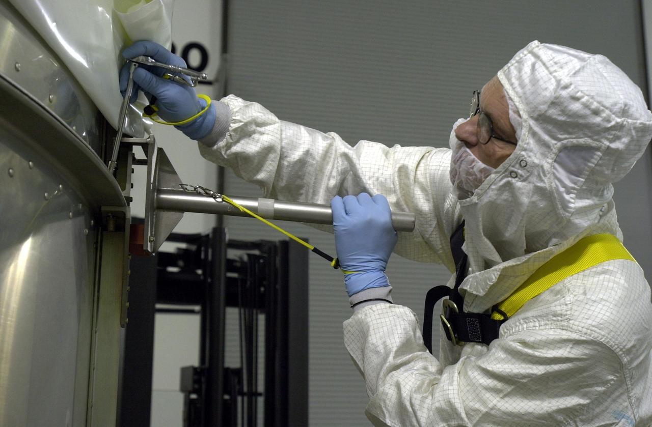 VANDENBERG AIR FORCE BASE, Calif. - Inside the Astrotech Payload Processing Facility on Vandenberg Air Force Base in California, a worker secures the transport canister around the dual spacecraft CALIPSO and CloudSat. The spacecraft will be moved to Space Launch Complex 2. There the spacecraft will be lifted and mated with a Boeing Delta II rocket for launch on April 21. CALIPSO stands for Cloud-Aerosol Lidar and Infrared Pathfinder Satellite Observation. It will fly in combination with the CloudSat satellite to provide never-before-seen 3-D perspectives of how clouds and aerosols form, evolve, and affect weather and climate. CALIPSO and CloudSat will join three other satellites in orbit to enhance understanding of climate systems.