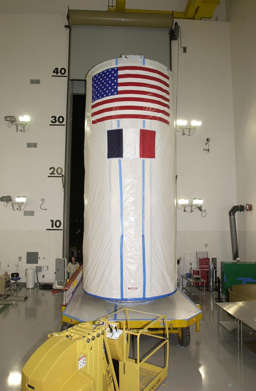 VANDENBERG AIR FORCE BASE, Calif.  -   Inside the Astrotech Payload Processing Facility on Vandenberg Air Force Base in California, the dual spacecraft CALIPSO and CloudSat, covered by a transport canister, is lowered onto a transporter.  The spacecraft is being moved to Space Launch Complex 2. There the spacecraft will be lifted and mated with a Boeing Delta II rocket for launch on April 21.  CALIPSO stands for Cloud-Aerosol Lidar and Infrared Pathfinder Satellite Observation. It will fly in combination with the CloudSat satellite to provide never-before-seen 3-D perspectives of how clouds and aerosols form, evolve, and affect weather and climate. CALIPSO and CloudSat will join three other satellites in orbit to enhance understanding of climate systems.  Launch of CALIPSO/CloudSat is scheduled for April 21.