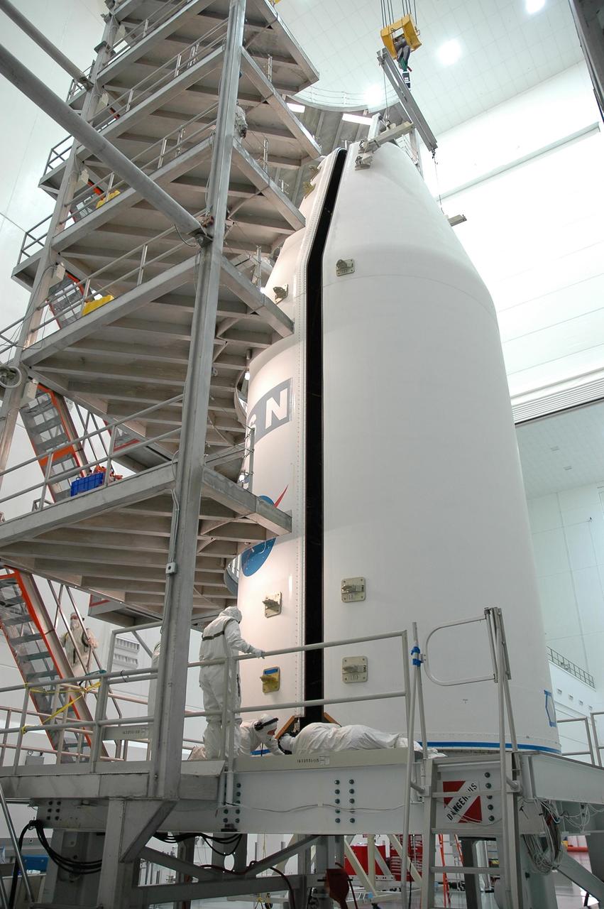 KENNEDY SPACE CENTER, FLA.  -  In the high bay at Astrotech Space Operations in Titusville, Fla., workers check the bottom of the fairing halves as they close around the GOES-N satellite.  The fairing protects the spacecraft during launch and flight through the atmosphere. Once out of the atmosphere, the fairing is jettisoned.  GOES-N is the latest in a series of Geostationary Operational Environmental Satellites for NOAA and NASA providing continuous monitoring necessary for intensive data analysis. GOES-N will be launched May 18 on a Boeing Delta IV rocket from Cape Canaveral Air Force Station in Florida. Photo credit: NASA/Jack Pfaller