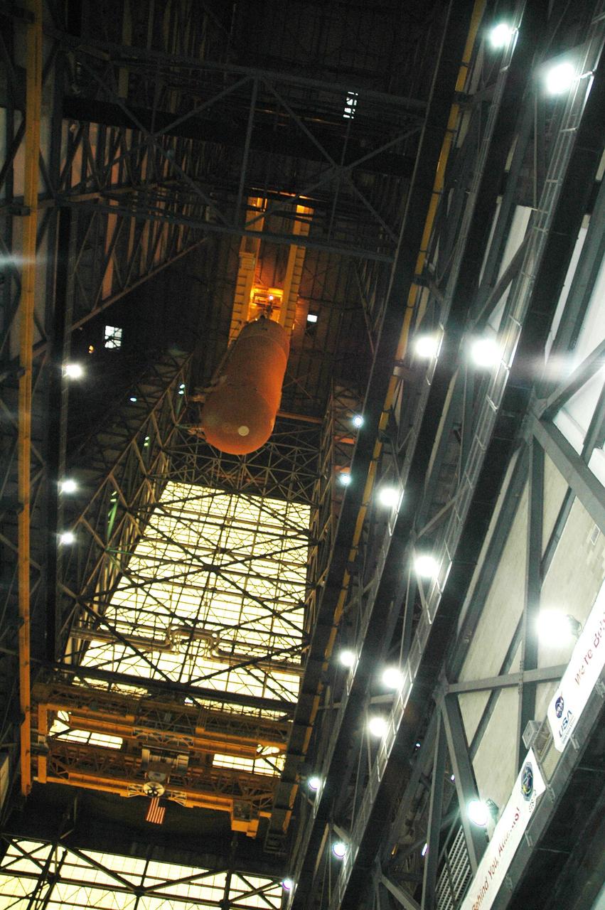 KENNEDY SPACE CENTER, FLA.  -  In the transfer aisle of the Vehicle Assembly Building, the external tank designated for Space Shuttle Discovery is lifted by crane up to the 16th level for the move to high bay 3. There it will be stacked with the solid rocket boosters already in place on the mobile launcher platform.  Discovery is scheduled to launch on mission STS-121 in July.  Photo credit: NASA/Amanda Diller