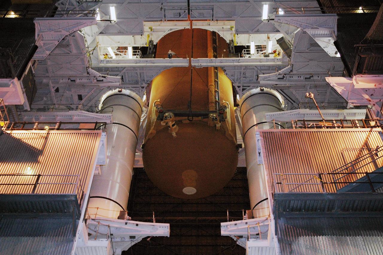 KENNEDY SPACE CENTER, FLA. - In high bay 3 of the Vehicle Assembly Building, the external tank designated for Space Shuttle Discovery is lowered into position between the solid rocket boosters on the mobile launcher platform. Discovery is scheduled to launch on mission STS-121 in July. Photo credit: NASA/Amanda Diller
